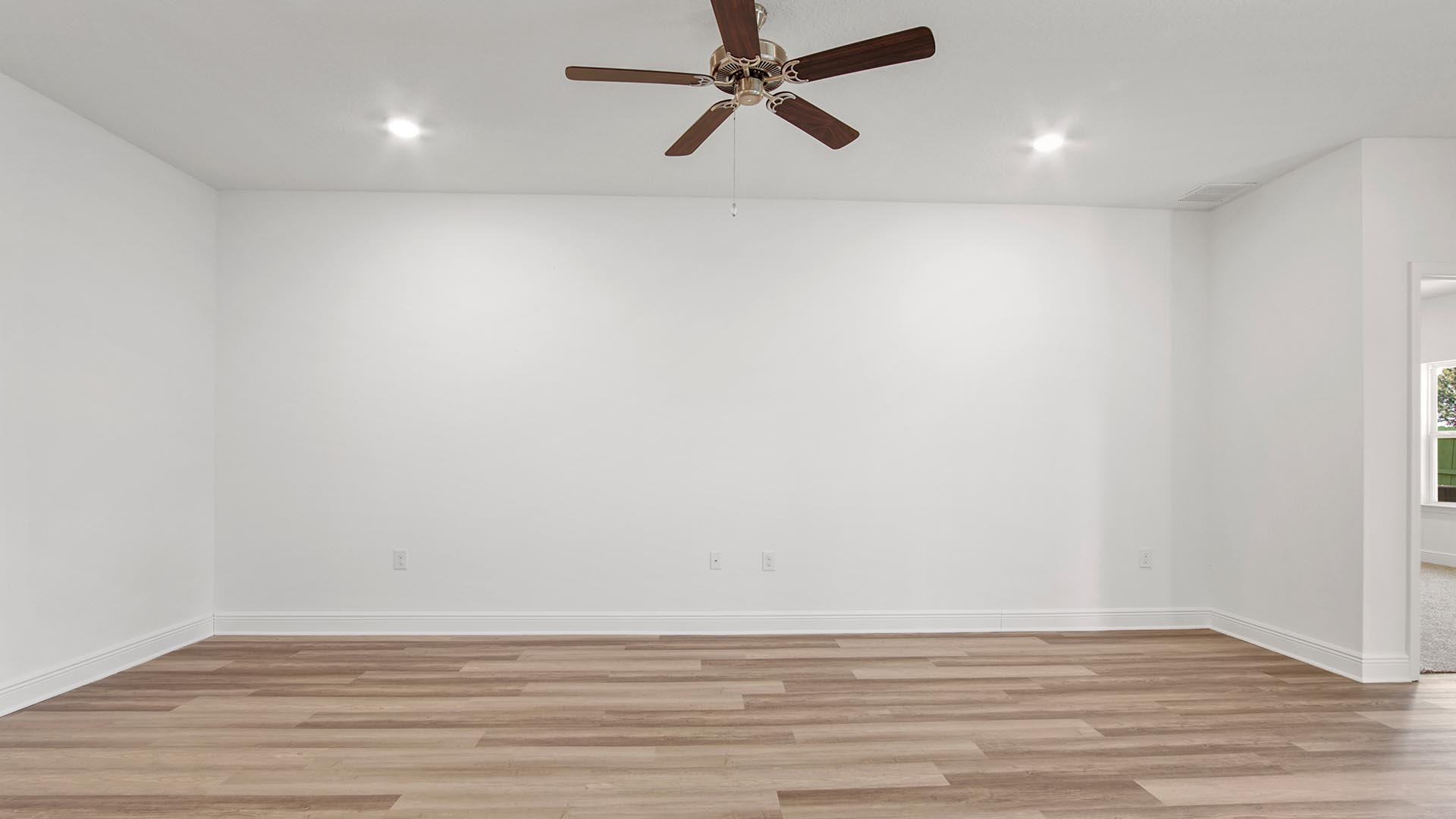 Large living area with ceiling fan and EVP flooring