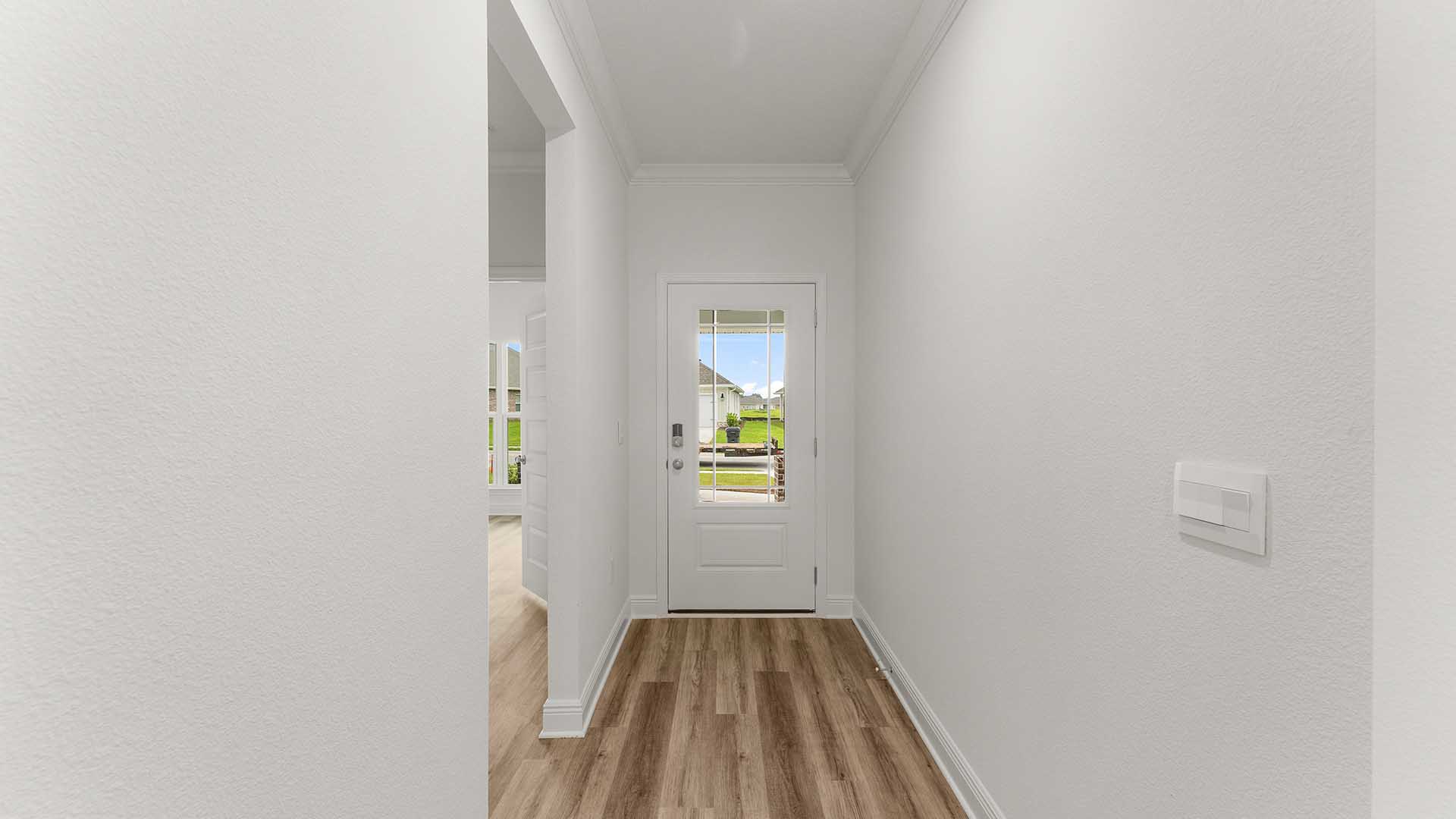 Foyer with EVP flooring and hallway to guest bedrooms and full bathroom and linen closet.