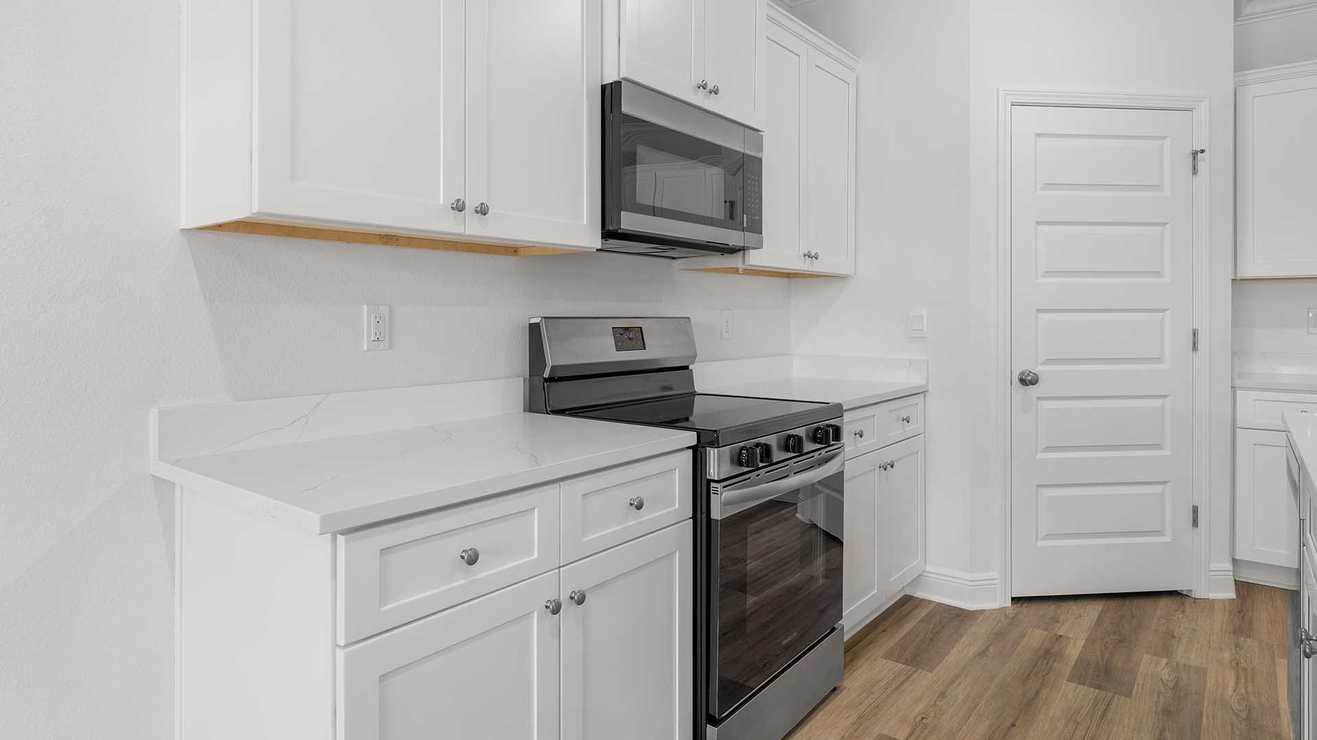 Stainless appliances in the kitchen include a smooth top stove, microwave and dishwasher