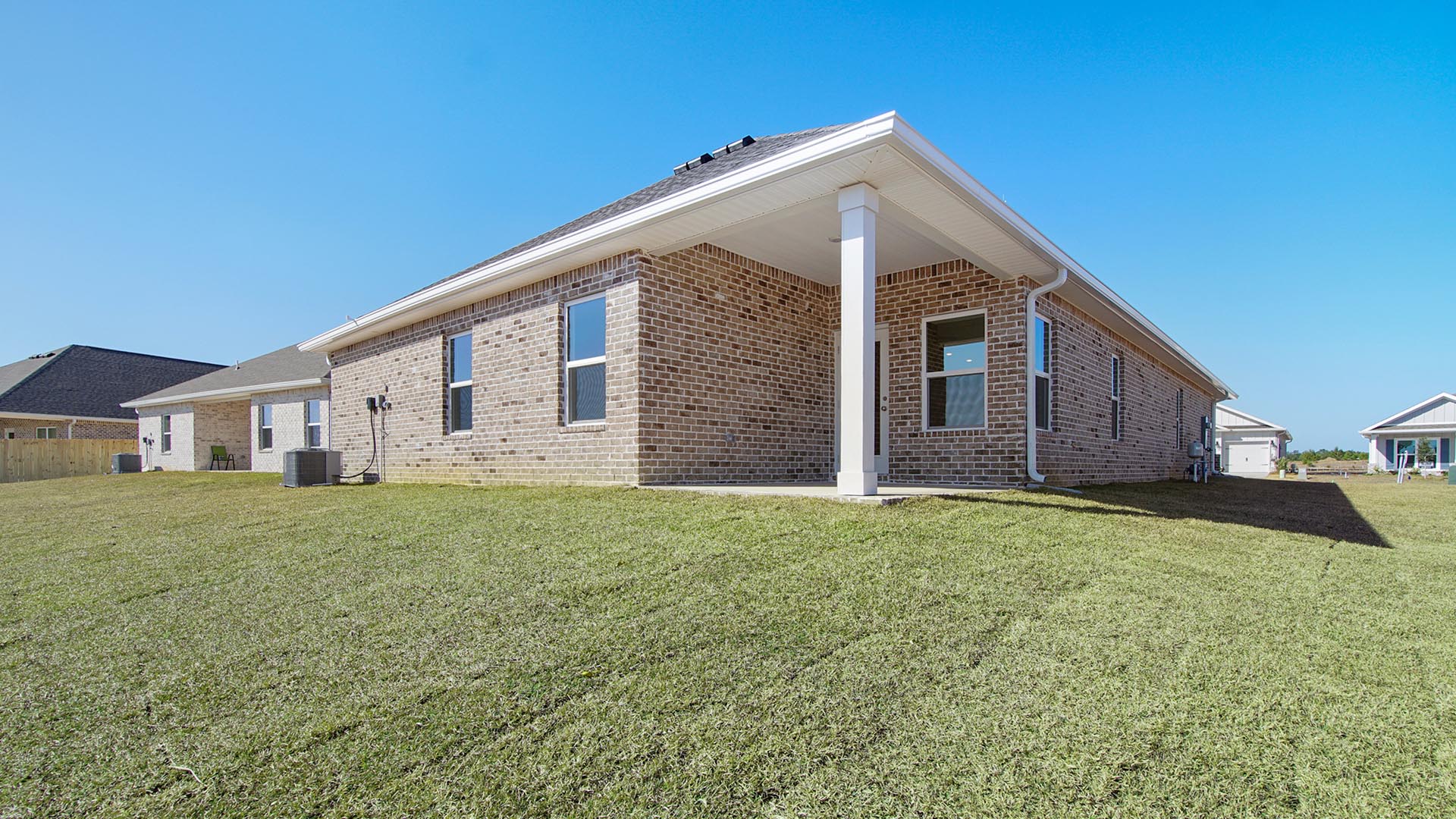 The back patio is covered and offers space for a dining or seating area