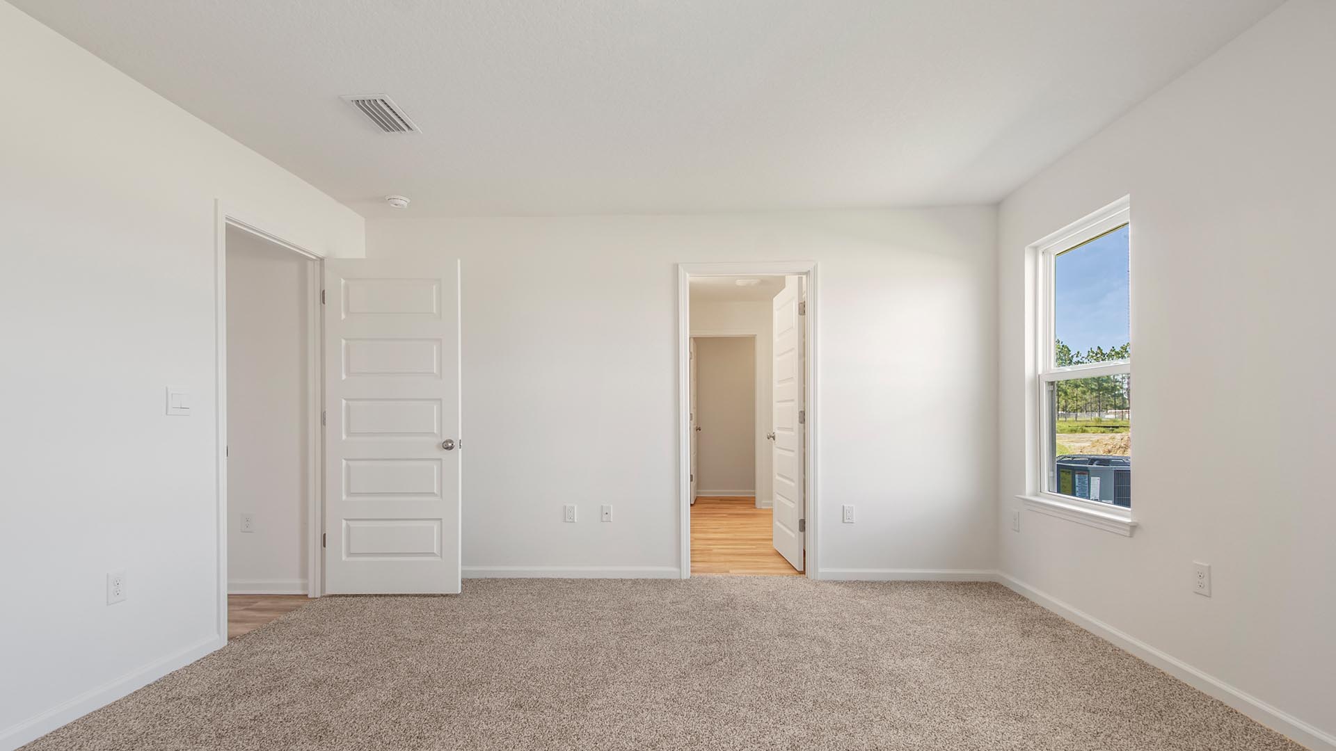 The primary bedroom is located at the back of the home and has carpet and a spacious ensuite bathroom