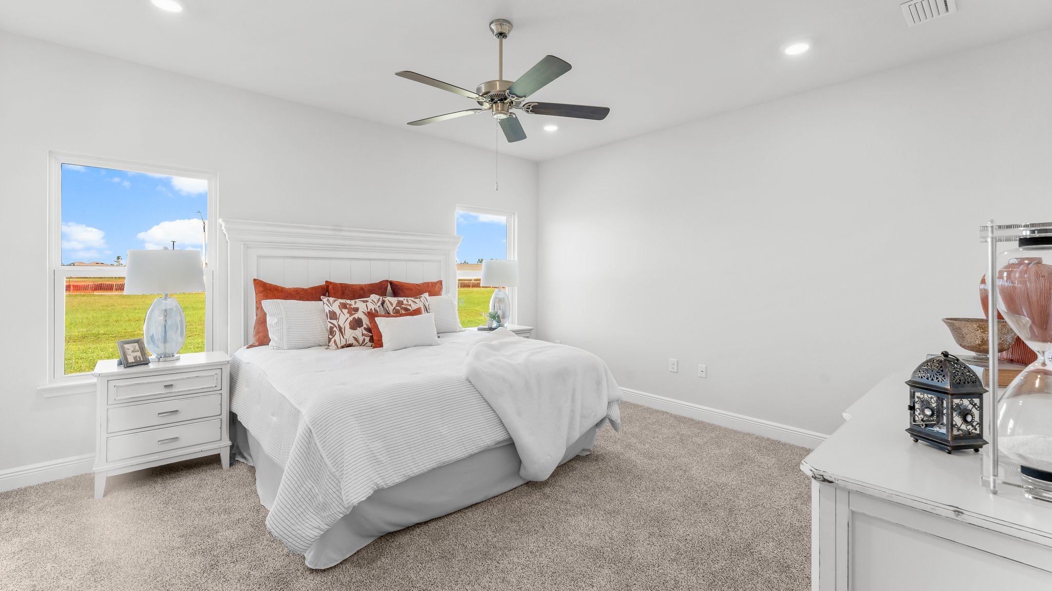 The primary bedroom has carpet and a ceiling fan