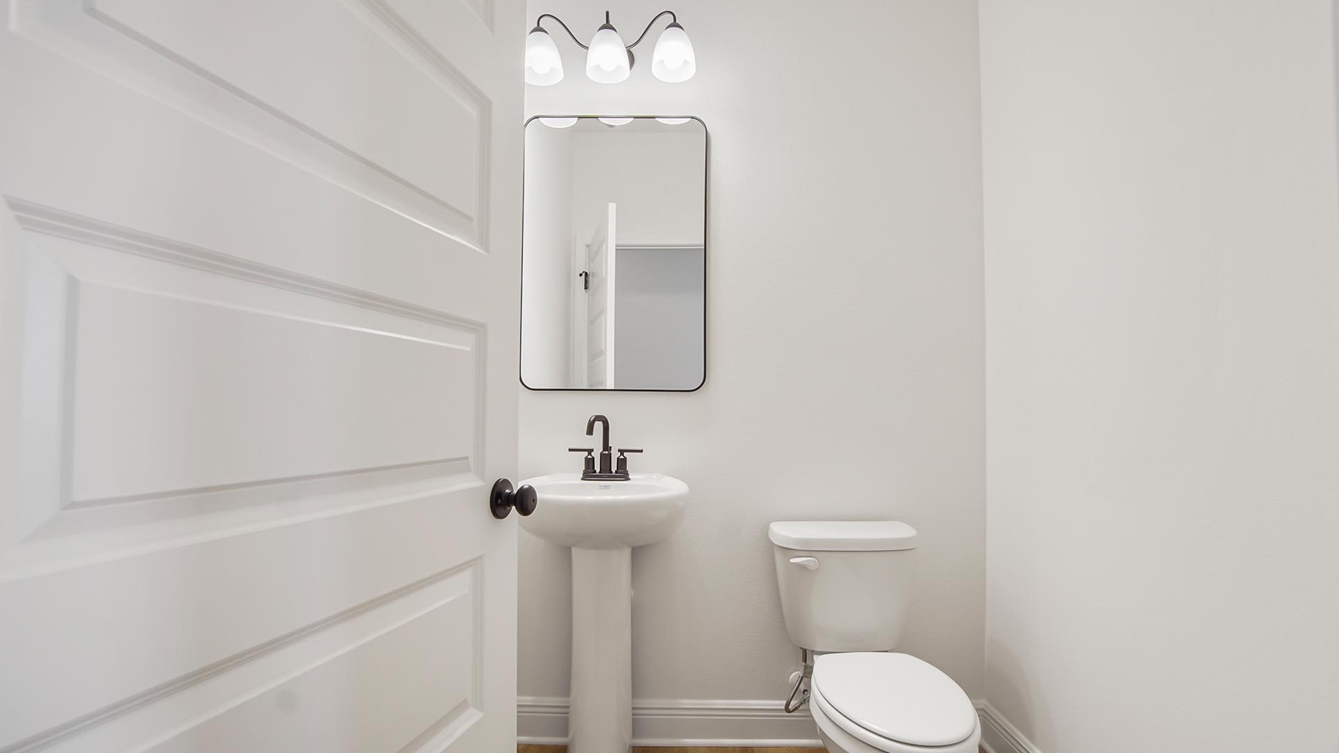 There is a hall bath with a pedestal sink