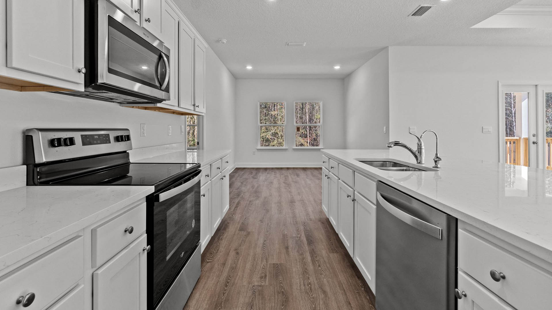 Kitchen with quartz countertops and stainless steel appliances including a stove microwave and dishwasher