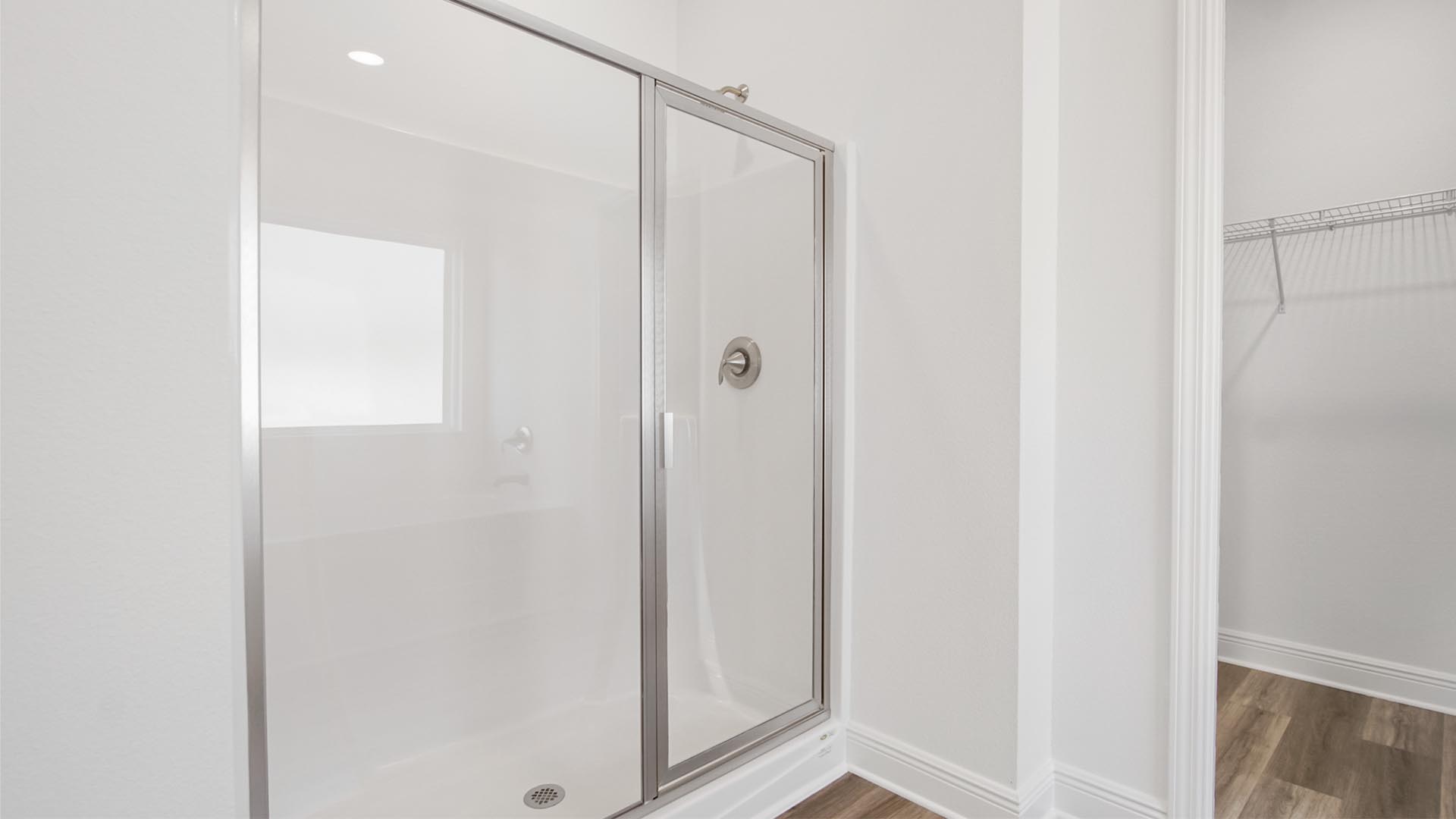 The primary bathroom features a large shower with glass enclosure