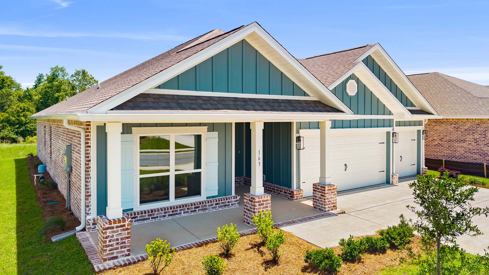 This home has a covered front porch and a three car garage