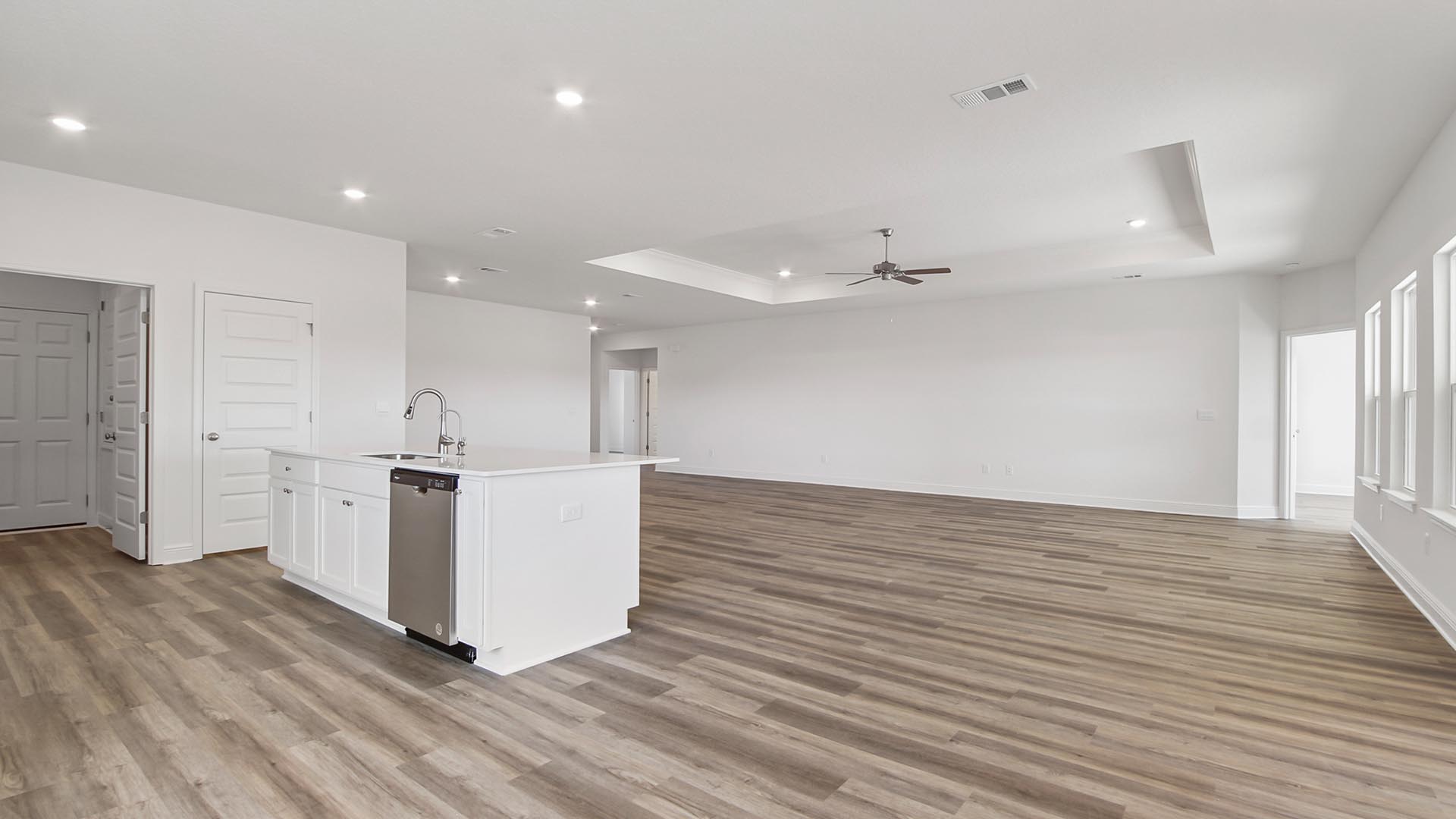 The kitchen dining and living areas are surrounded by windows for natural light