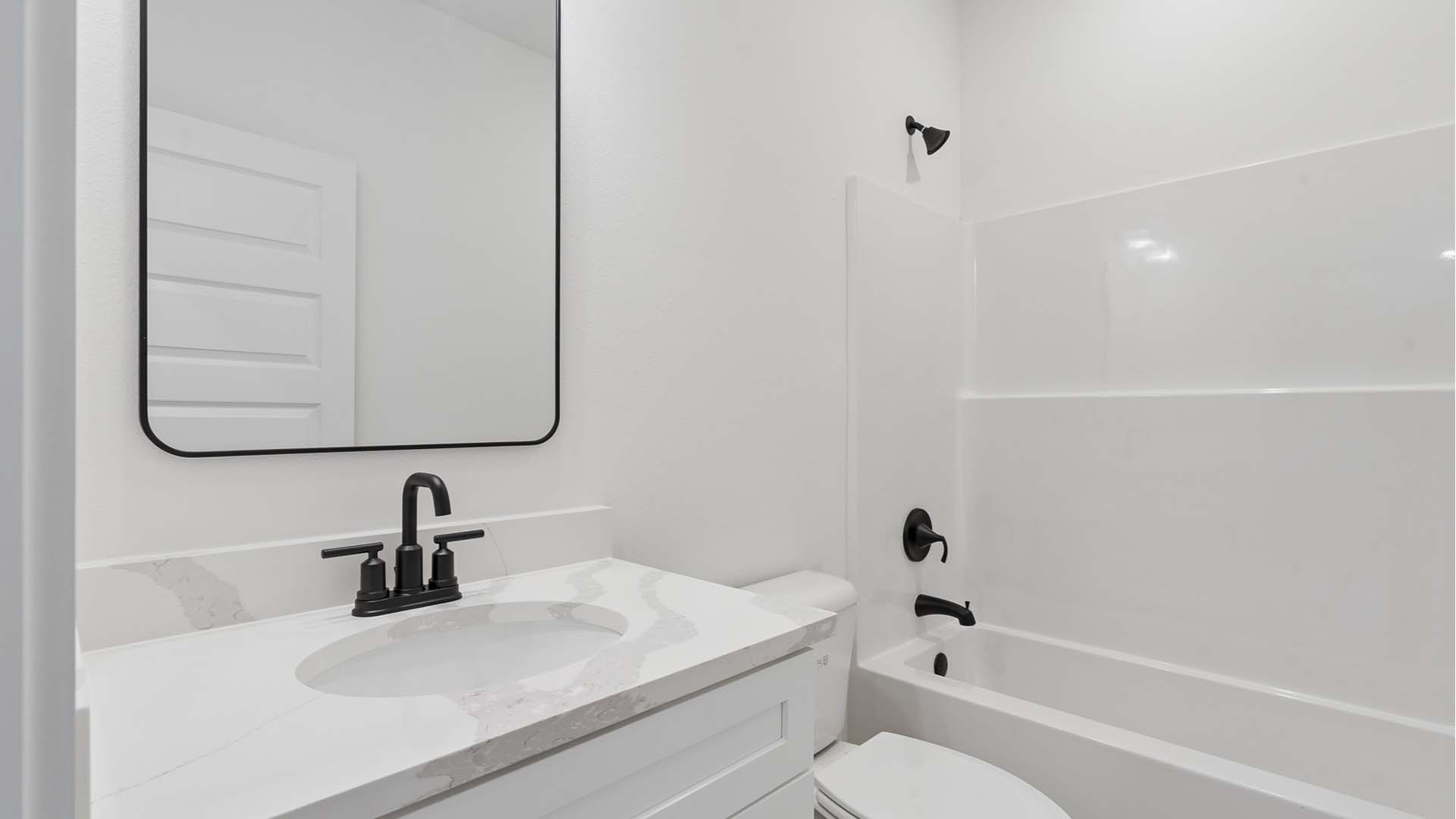 The shared bath has a single vanity and shower tub combination