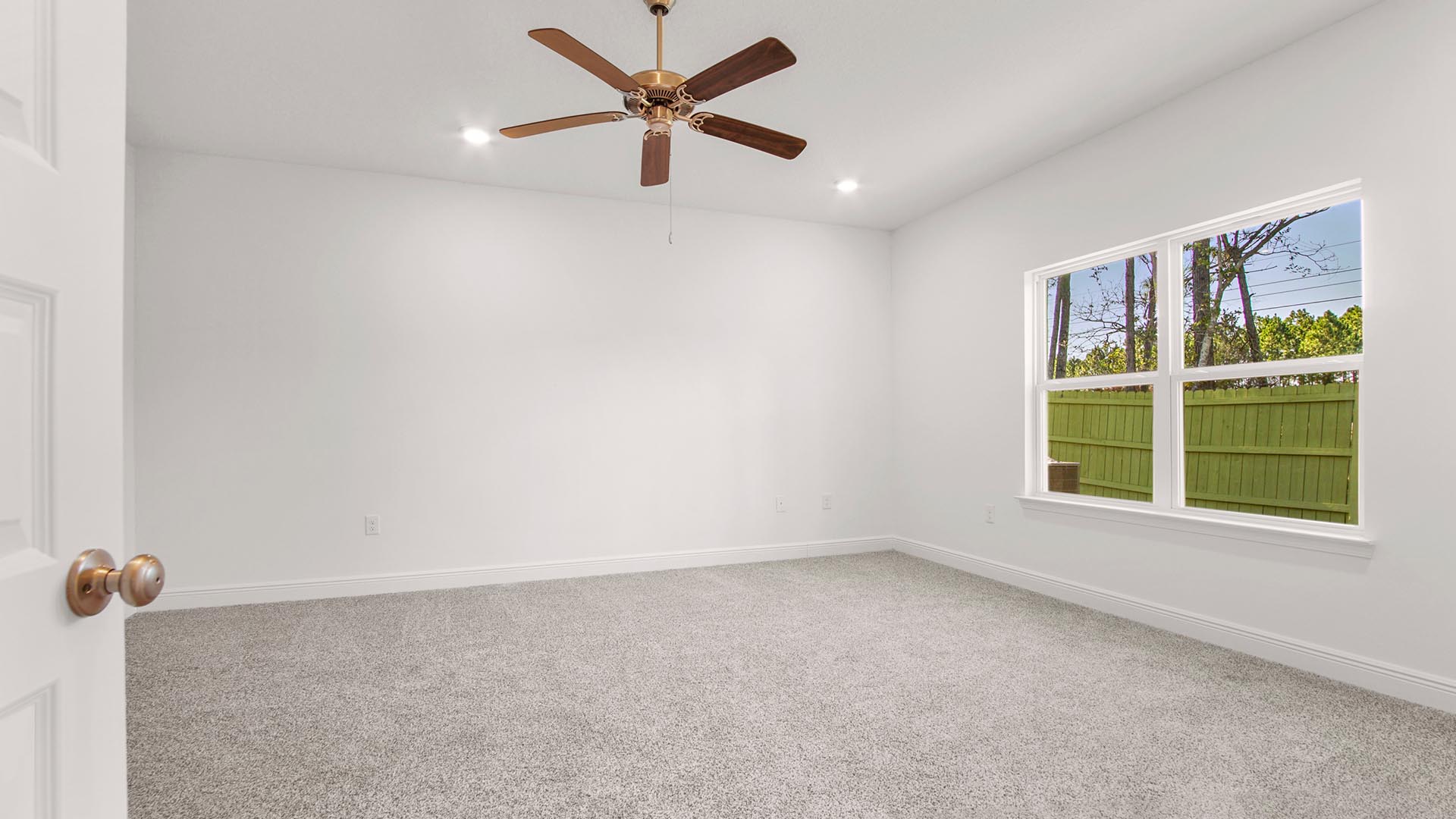 The primary bedroom features carpet and a ceiling fan