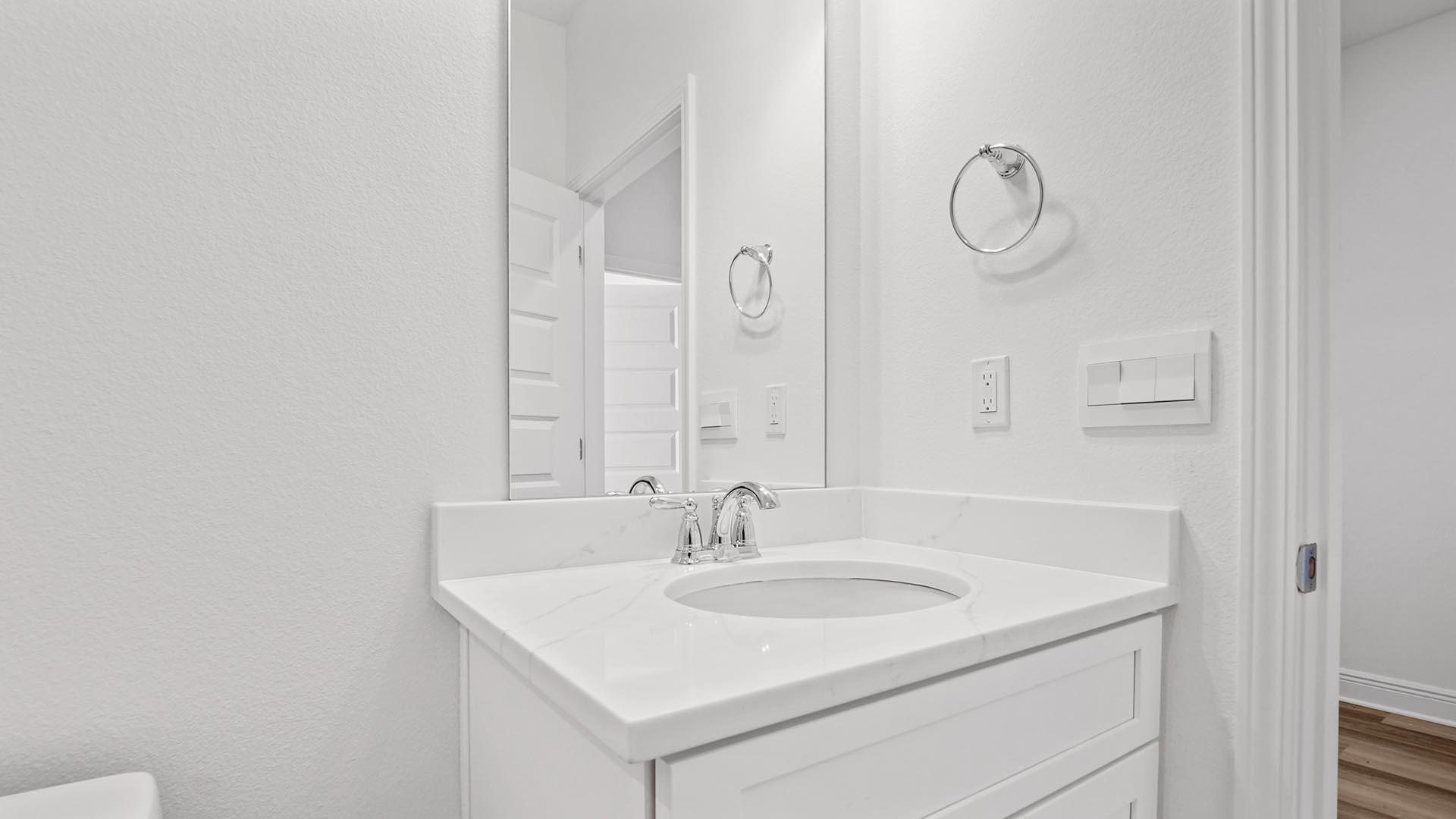 The shared bath features a single vanity with quartz countertops and lower cabinetry