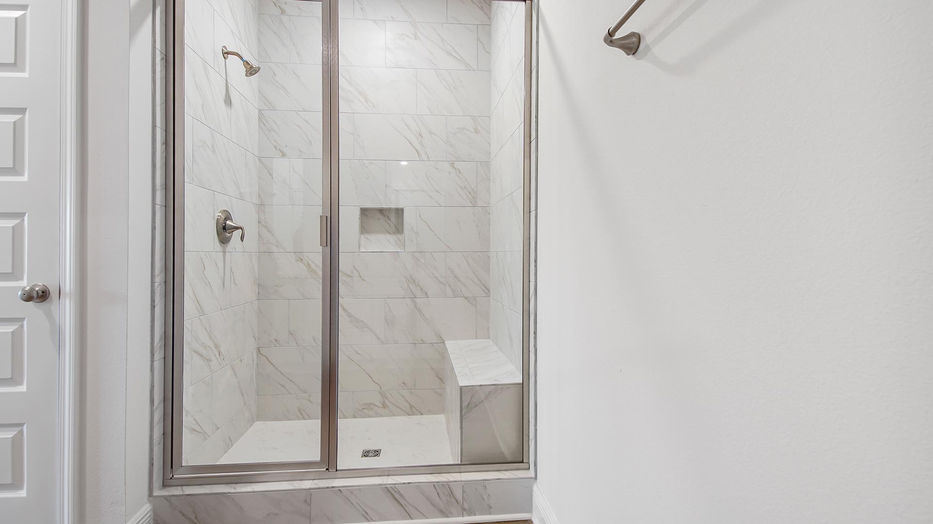 Oversize tile shower with bench allows for a luxurious spa like experience