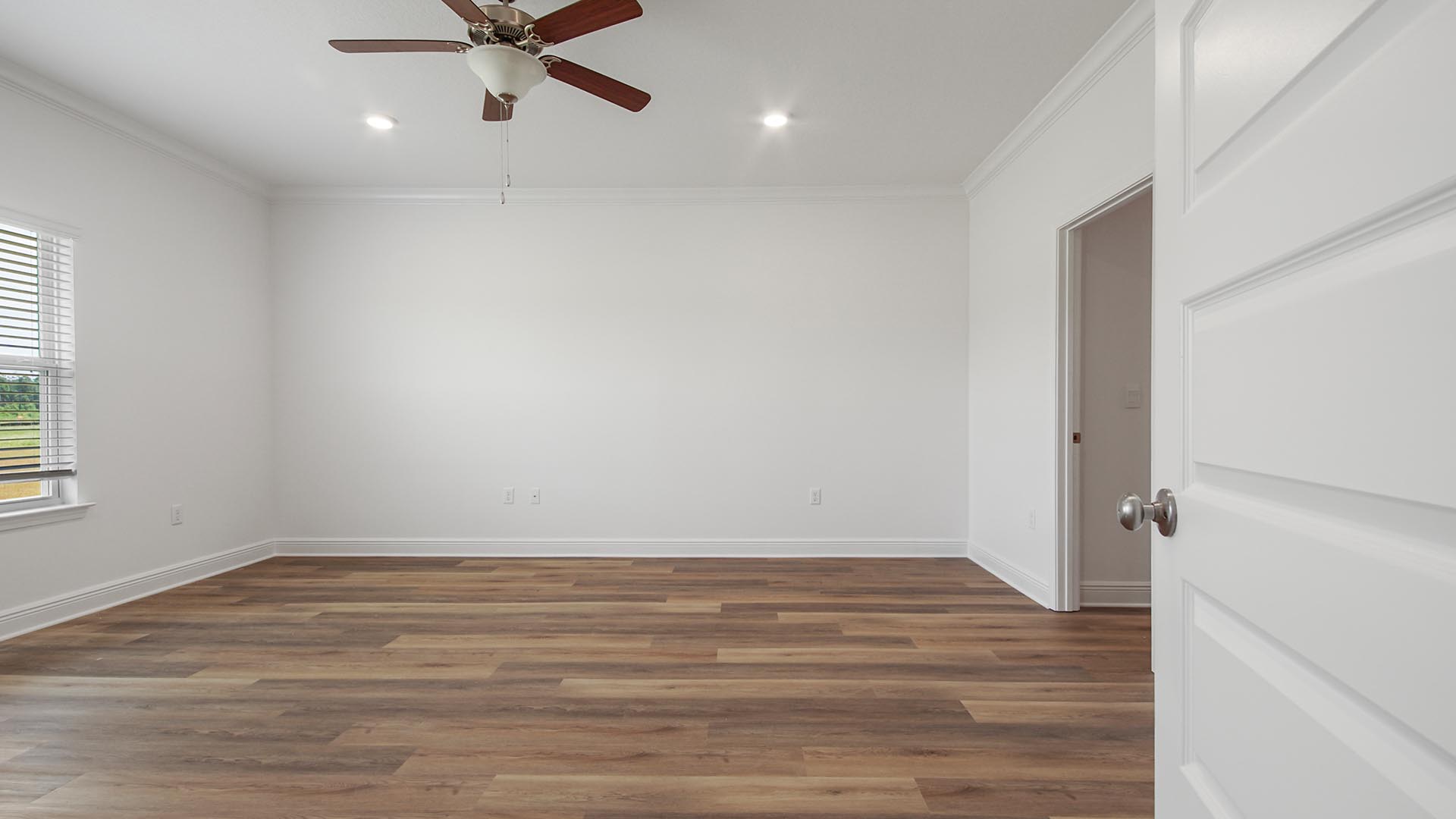 The primary bedroom has EVP flooring and is equipped with a ceiling fan