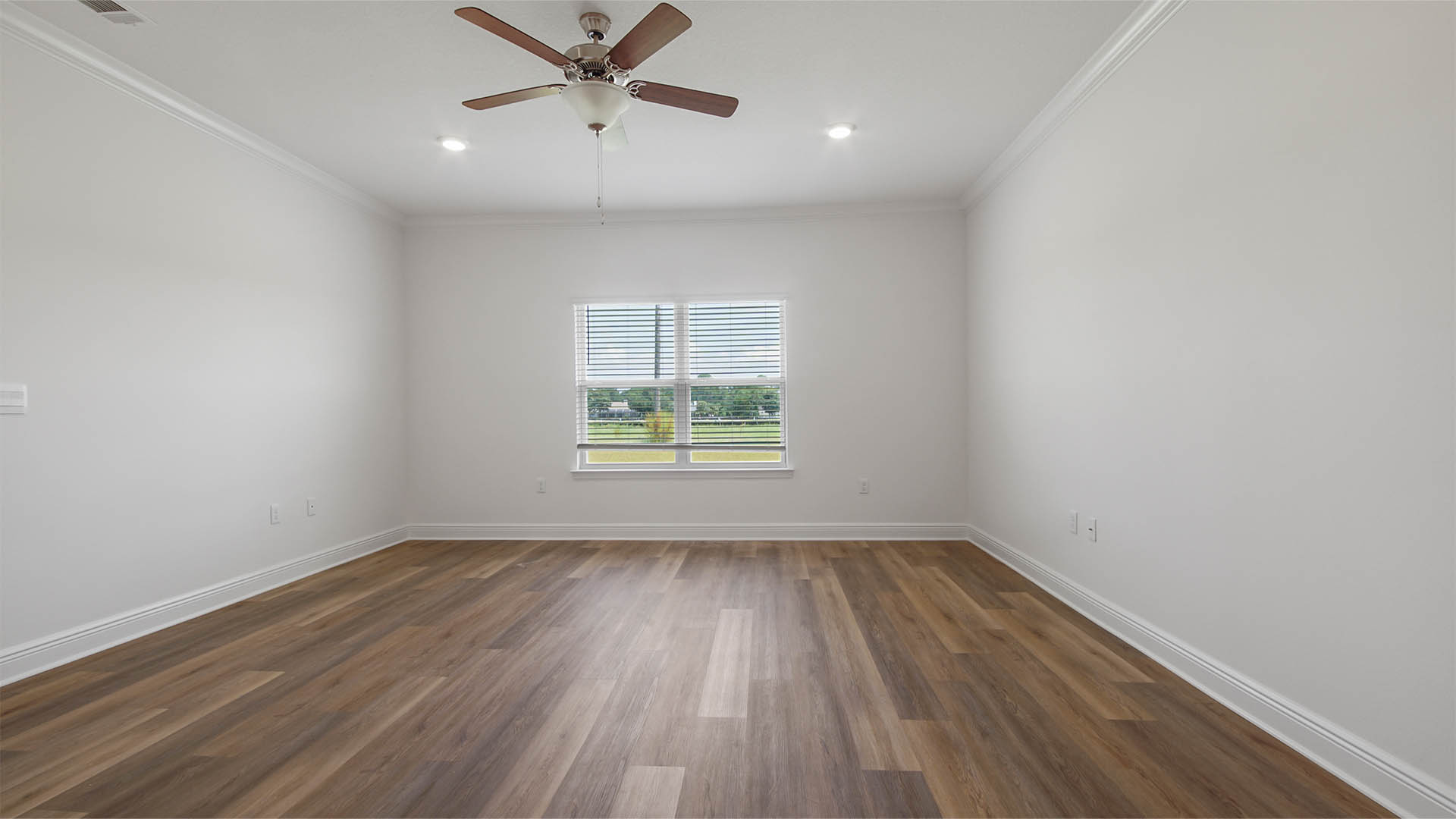 Primary bedroom with EVP flooring and ceiling fan and large window.