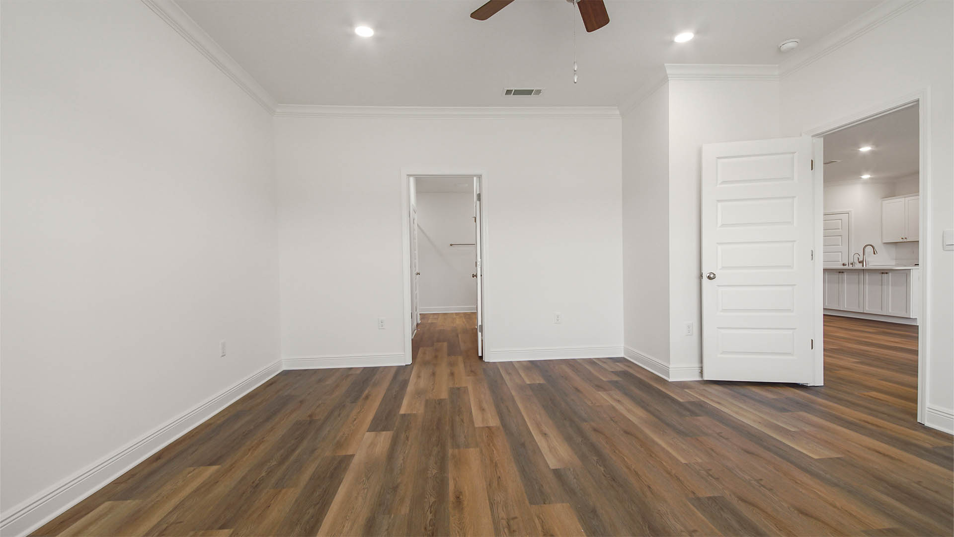 Primary bedroom with EVP flooring and bathroom entrance.