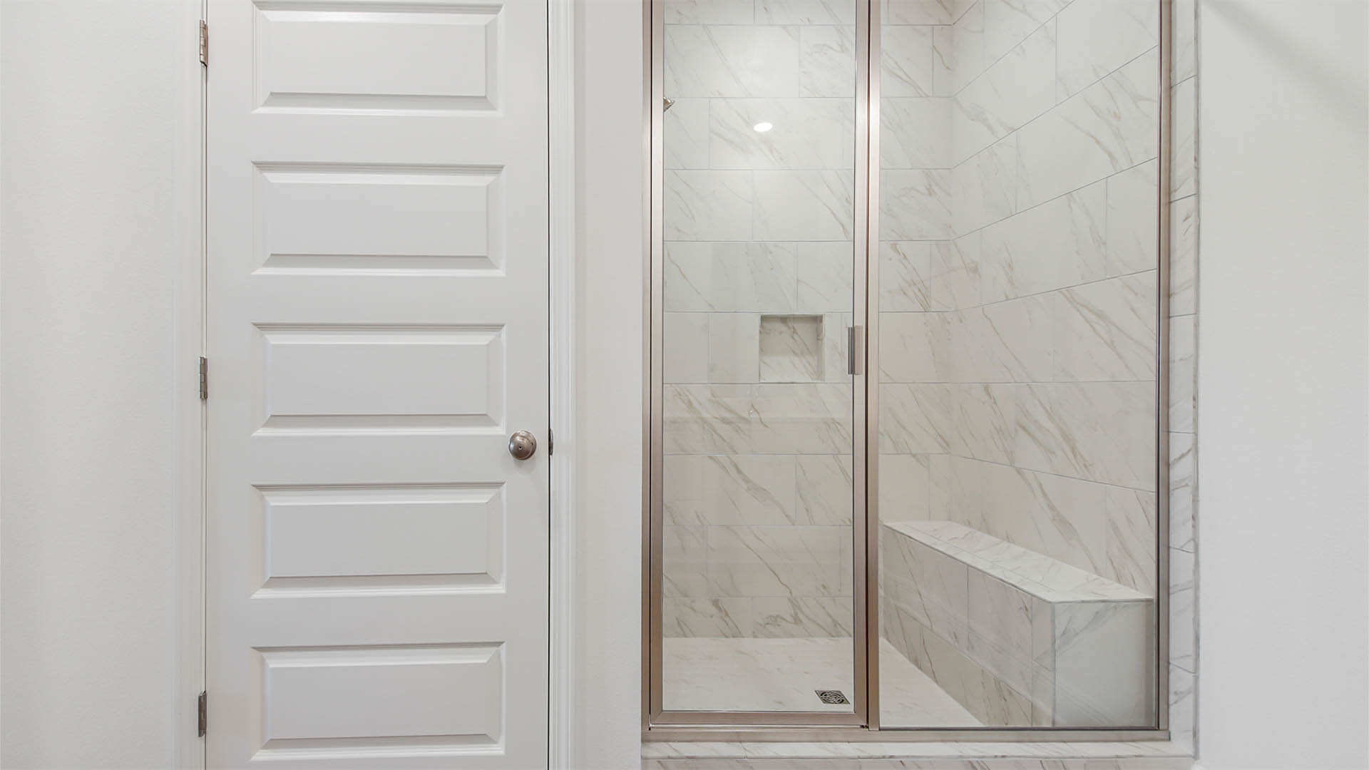 Primary bathroom with tile shower with bench.