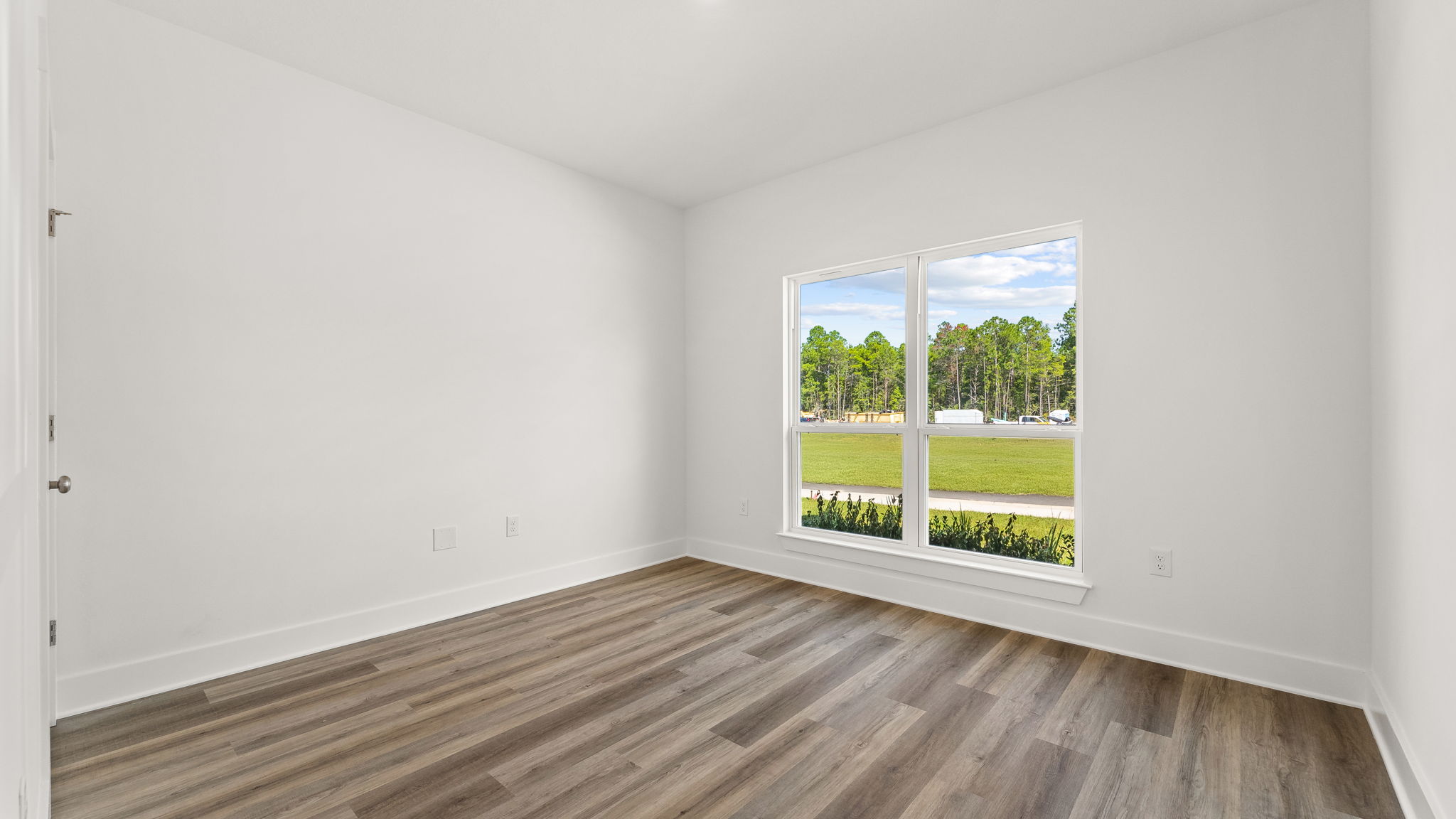 Guest bedroom three is located at the front of the home with a picture window