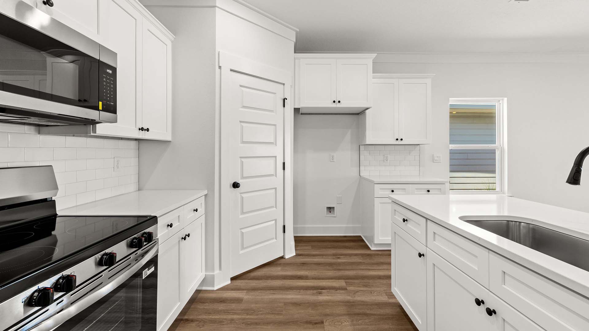 The kitchen has an island with quartz countertops and white cabinetry