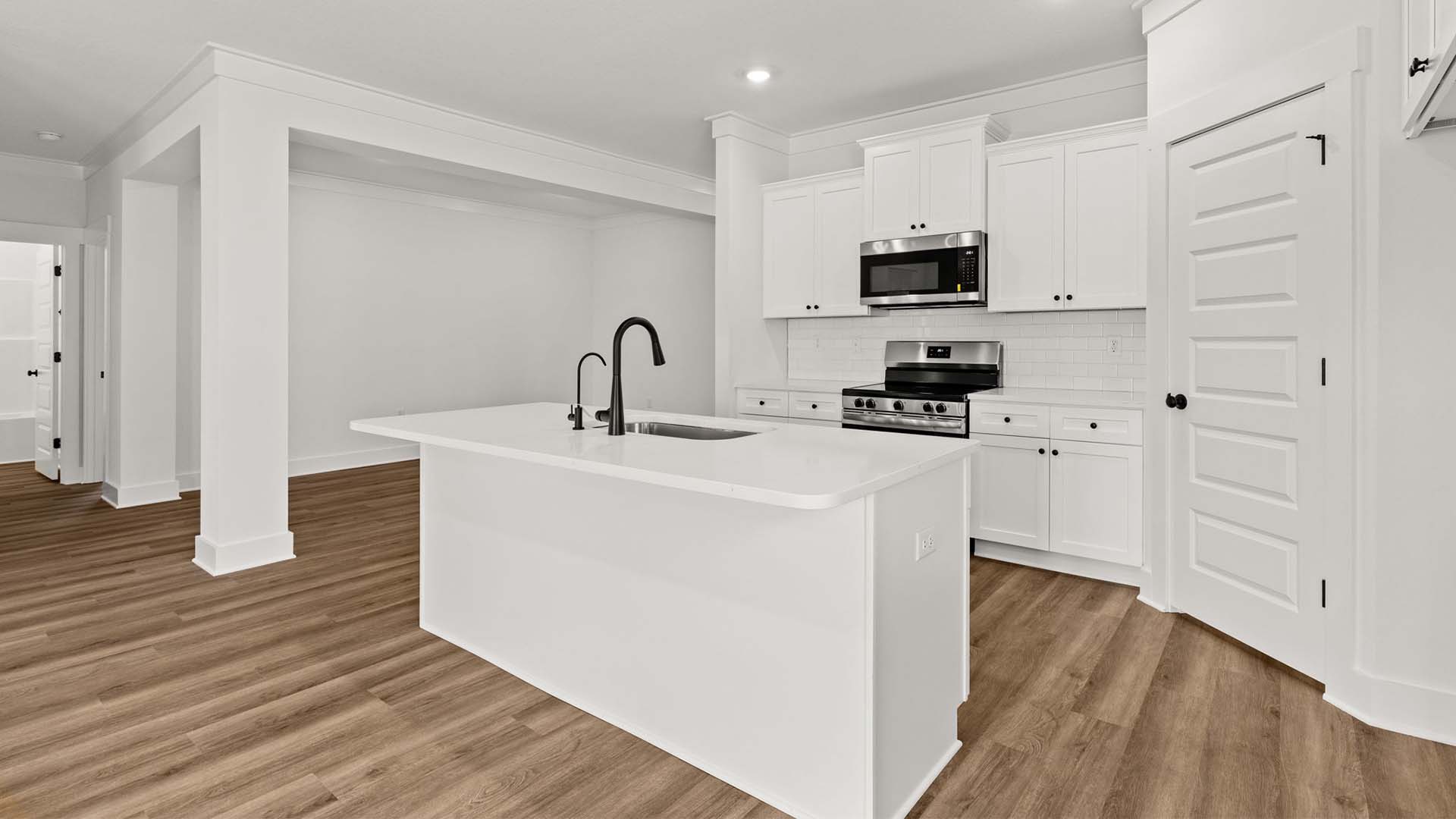 The kitchen has upper and lower cabinetry for storage and corner pantry