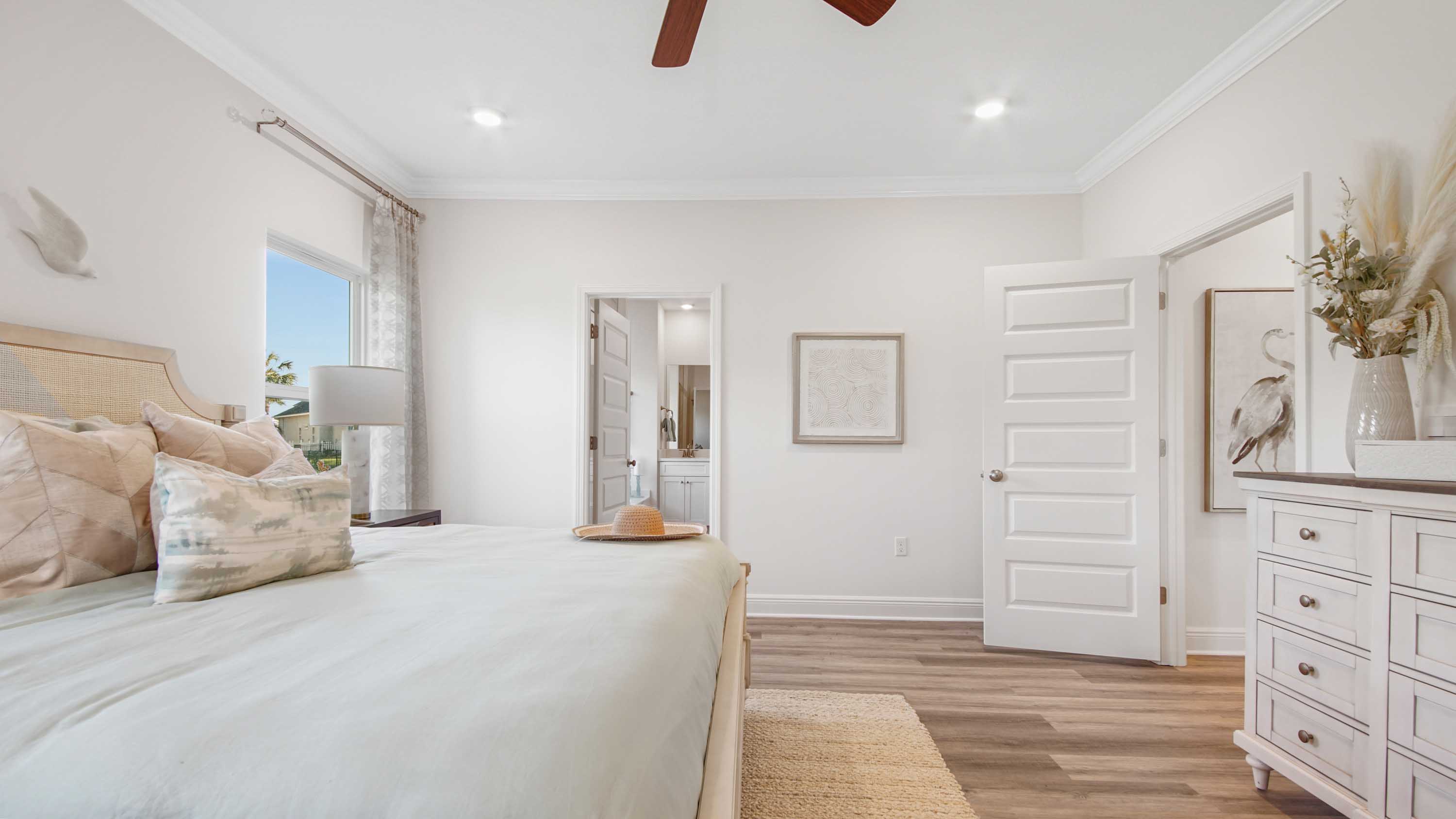 Primary bedroom with EVP flooring and bathroom entrance.