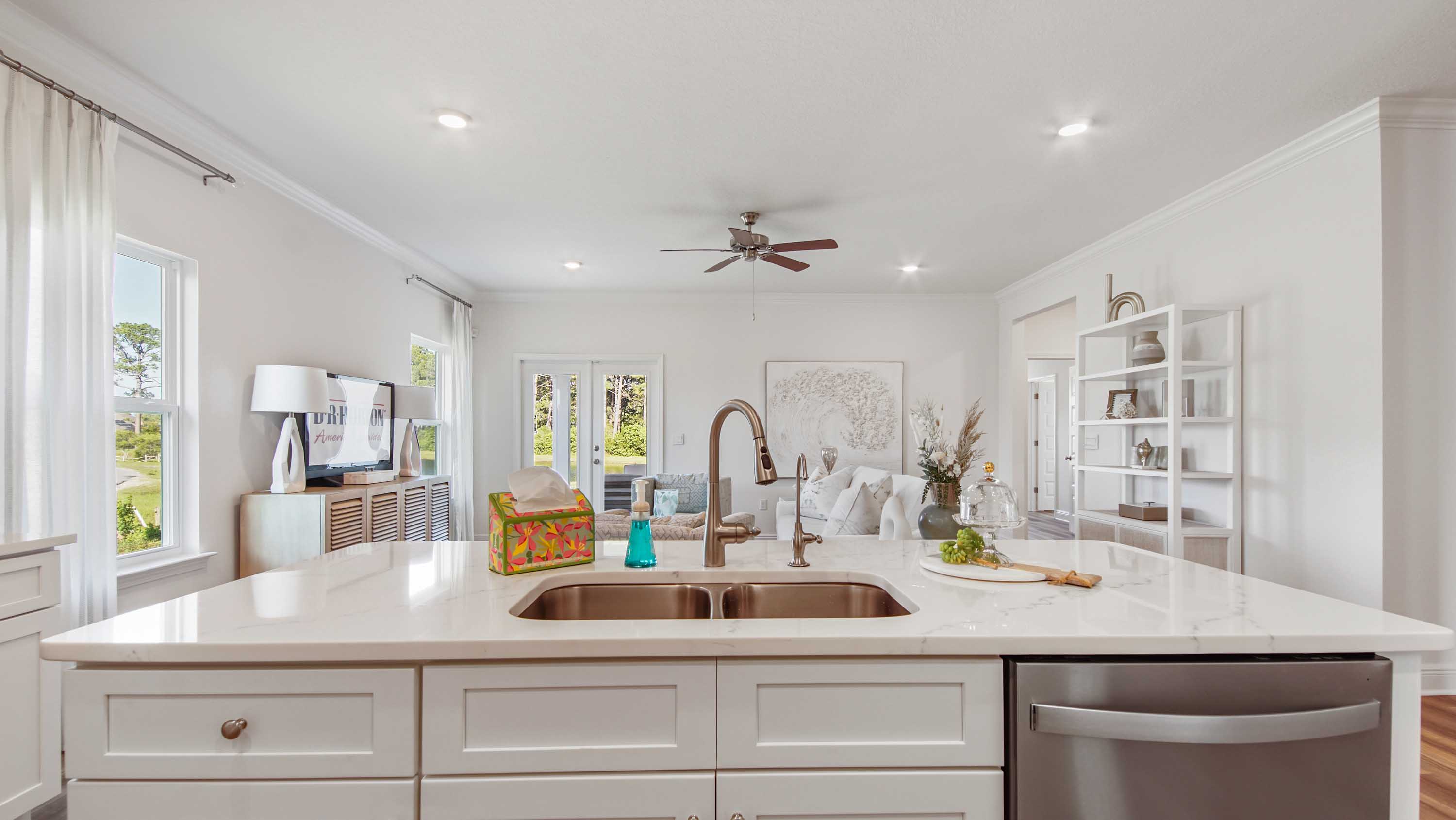 Kitchen island with under mount sink and dishwasher overlooking living area.