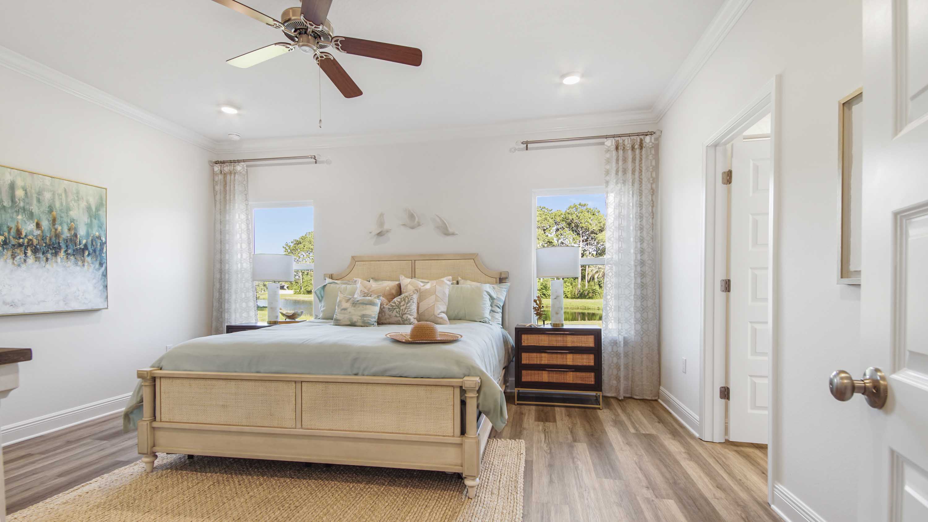 Spacious primary bedroom with EVP flooring and a ceiling fan