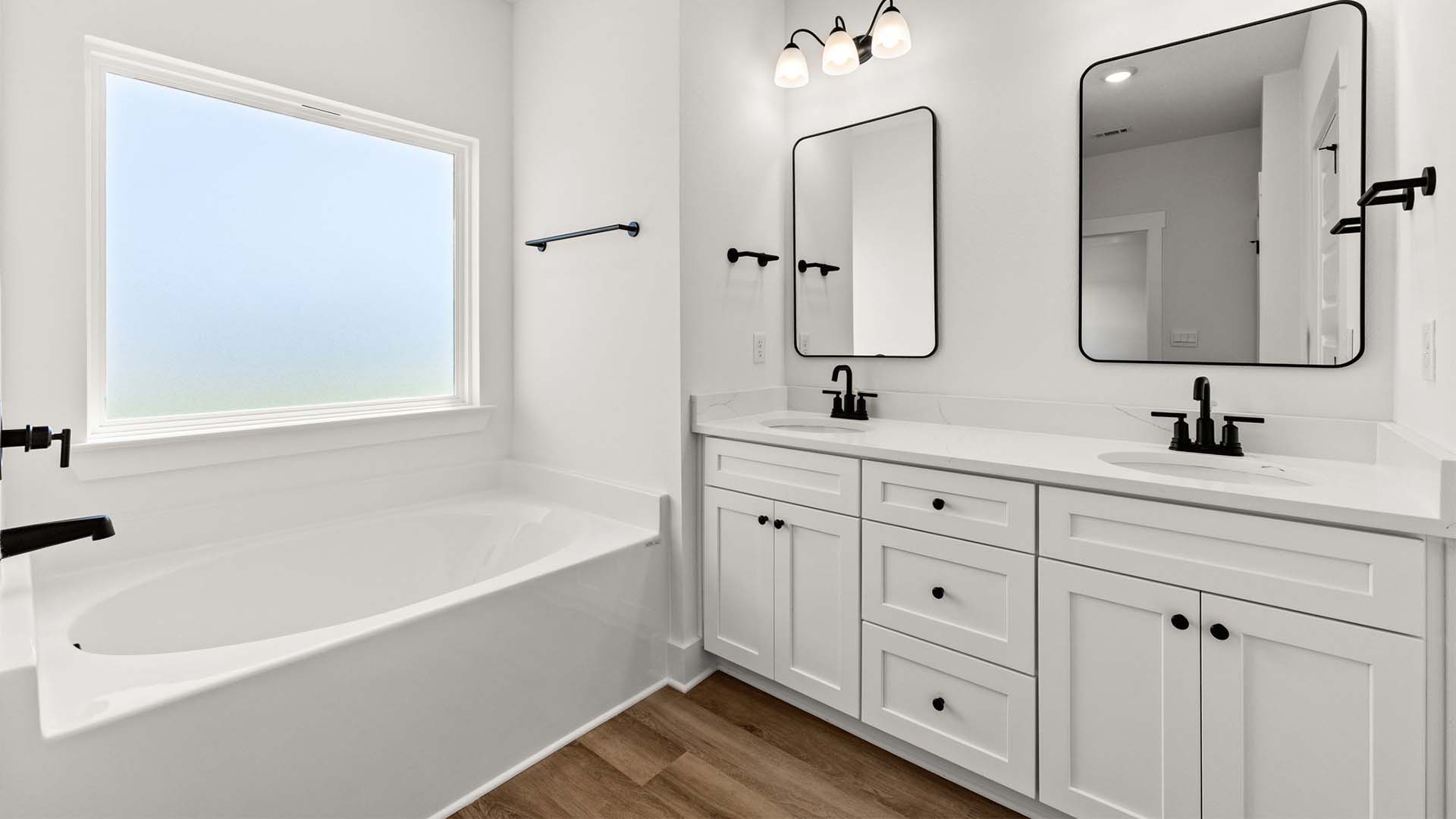 The primary bathroom has a dual sink vanity with lower cabinetry and drawers for storage