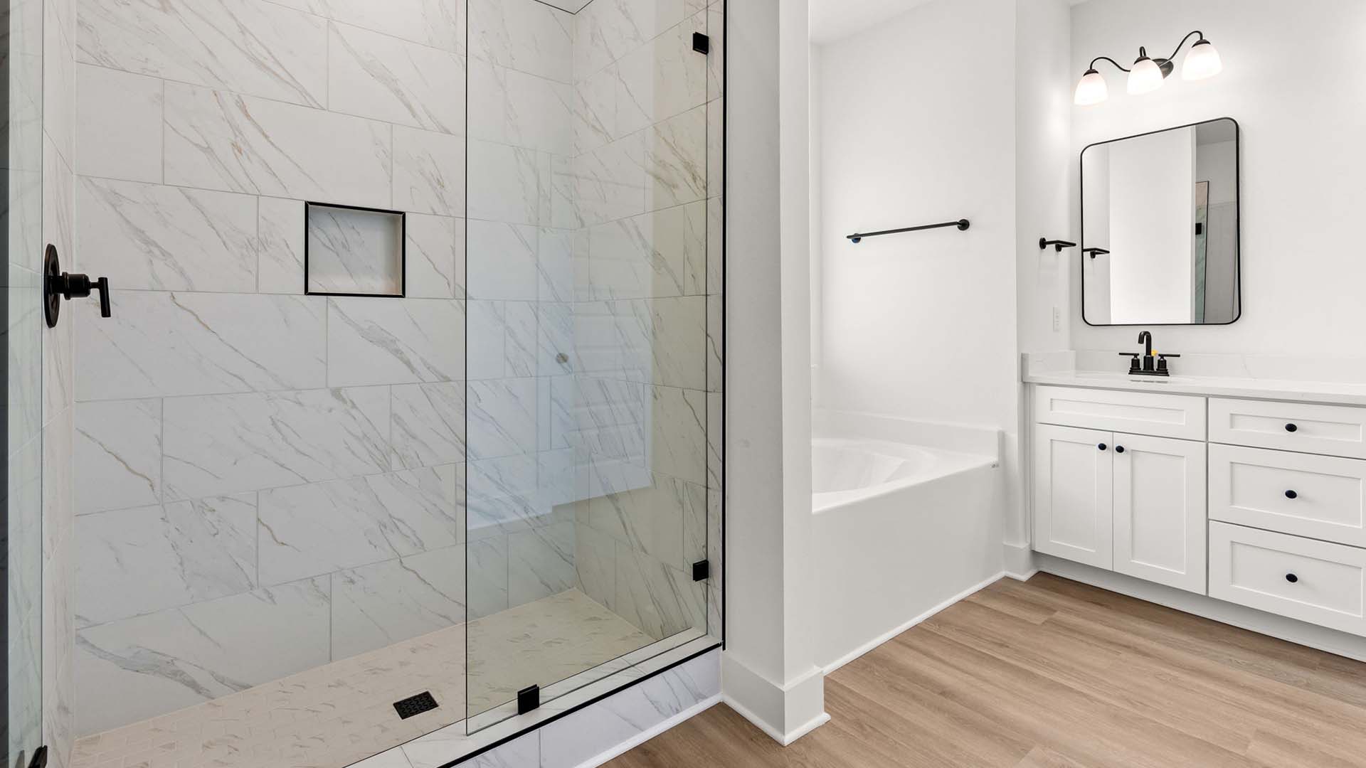 The primary bathroom has a tile shower with glass enclosure and a separate soak tub