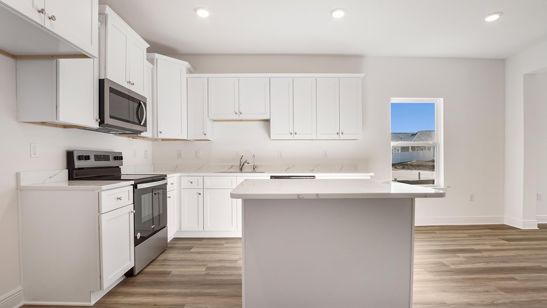 Open concept kitchen and living area with EVP flooring and quartz countertops and EVP flooring and a kitchen island.