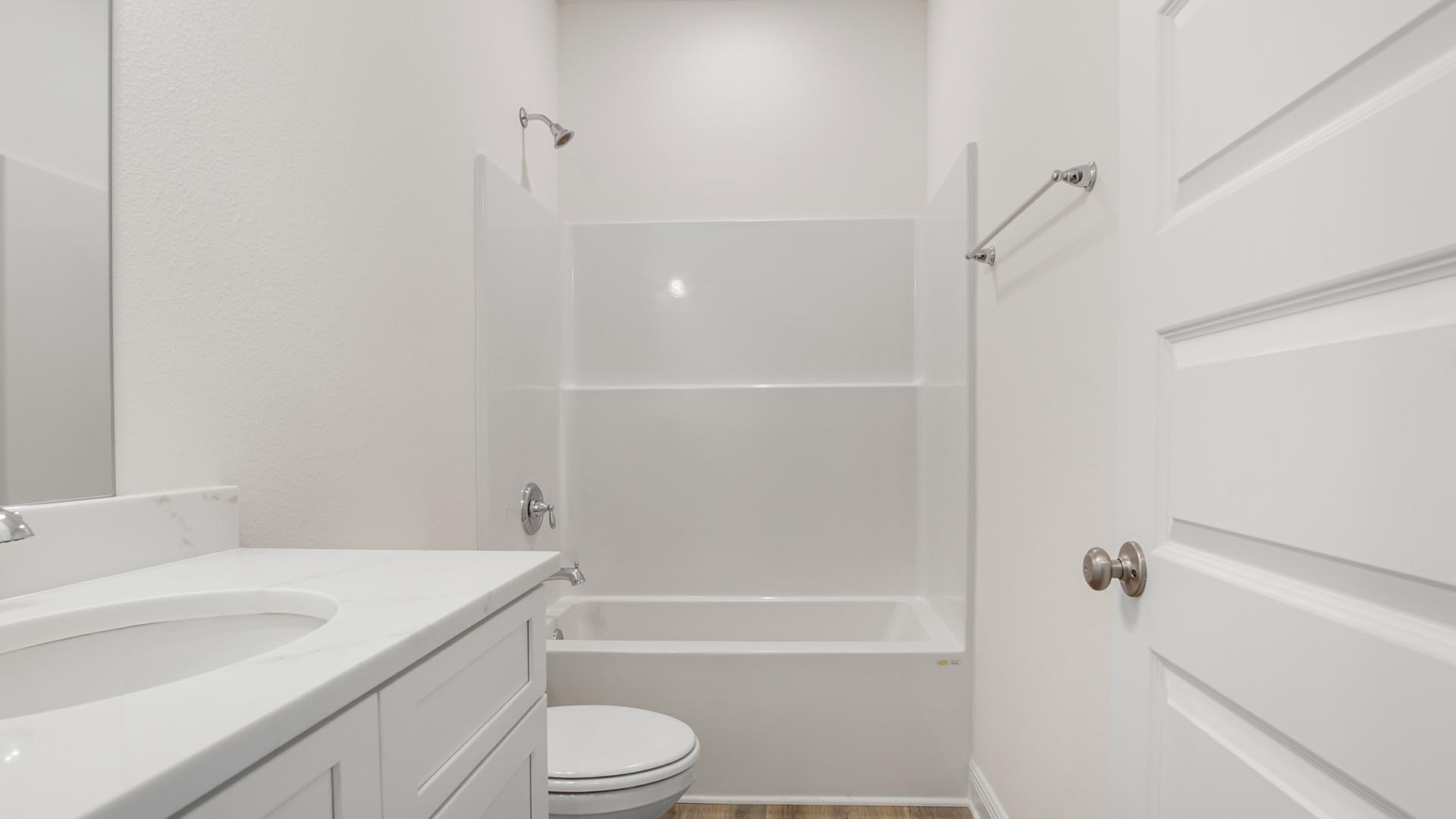 Shared bathroom with a shower tub combo and EVP flooring and single vanity with quarts countertops.