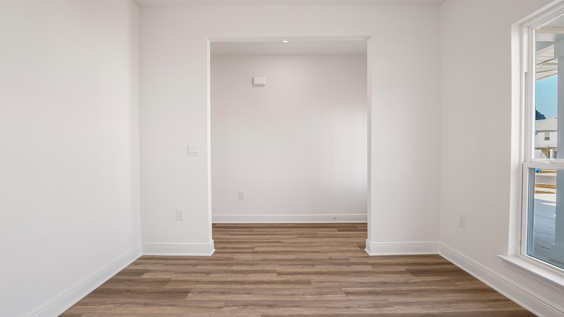 Flex space for an office or formal dining room with EVP flooring and large window.