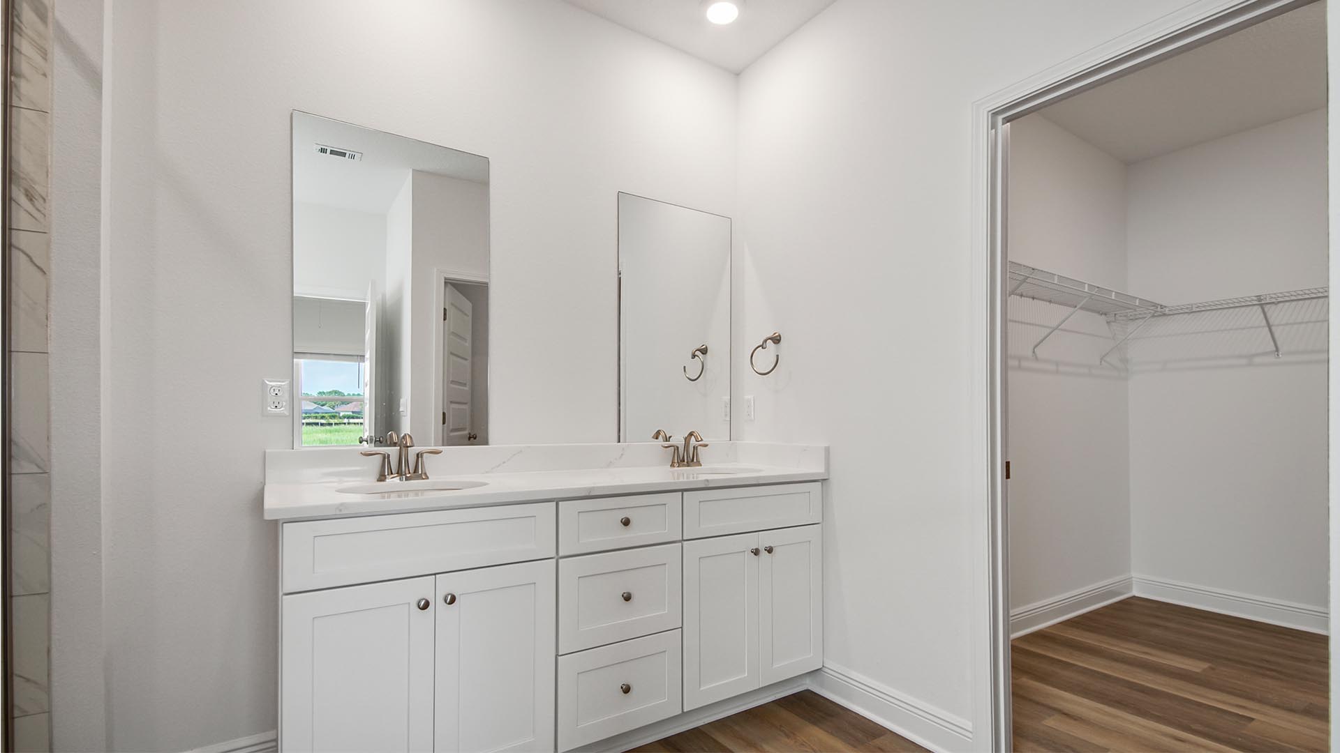 The primary bathroom features EVP flooring and quartz countertops