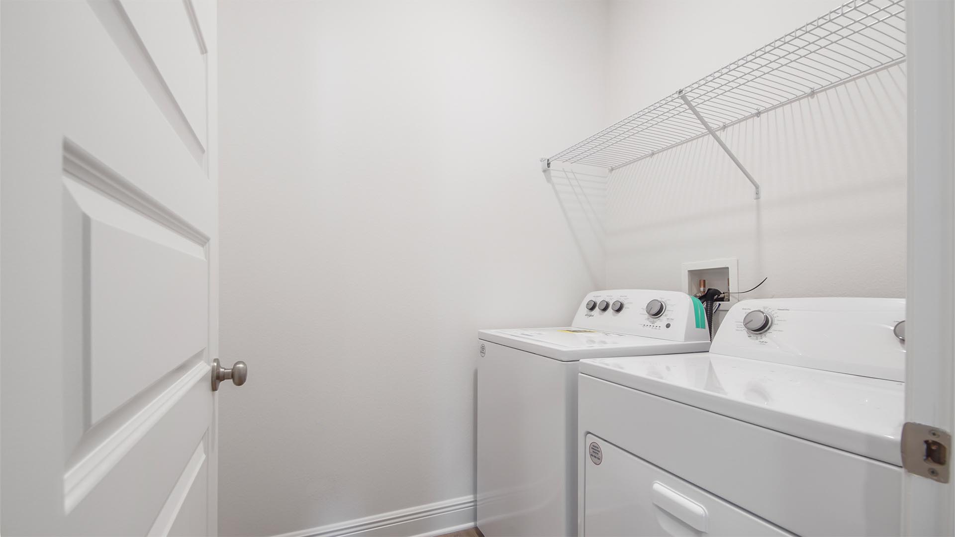 The spacious laundry room will accommodate a full size washer and dryer and features upper ventilated shelving and EVP flooring