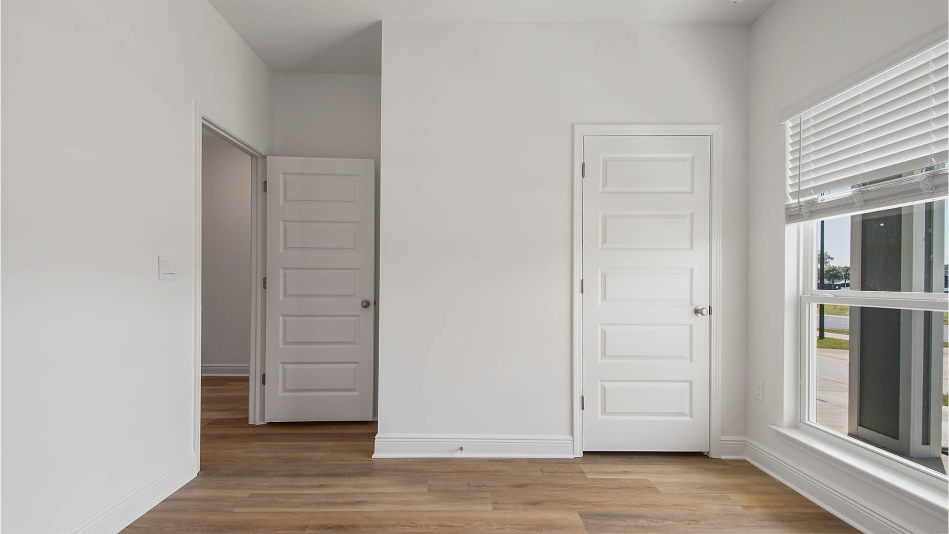 Bedroom two with EVP flooring and large window and closet.