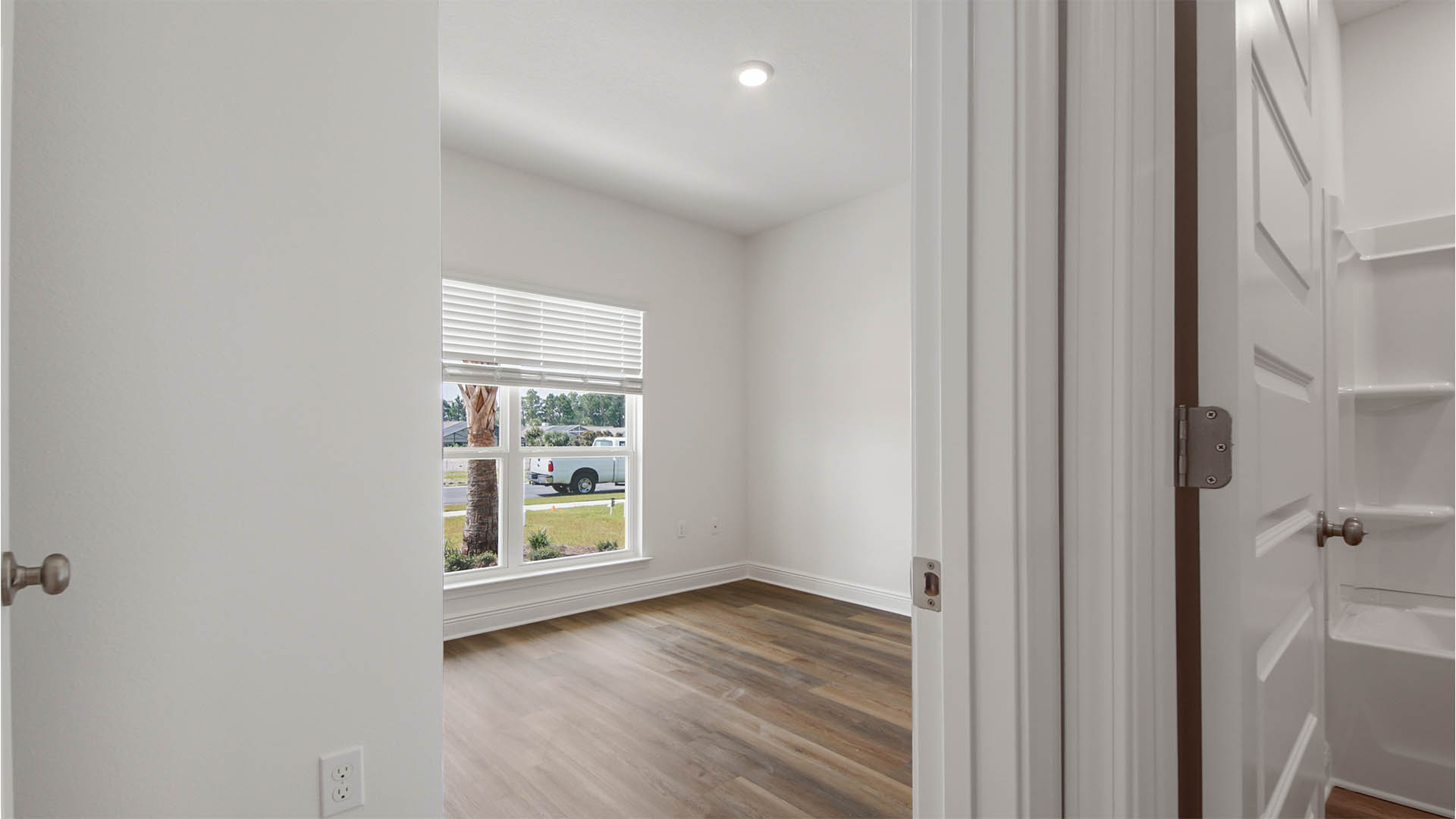 Bedroom two with EVP flooring and large window.