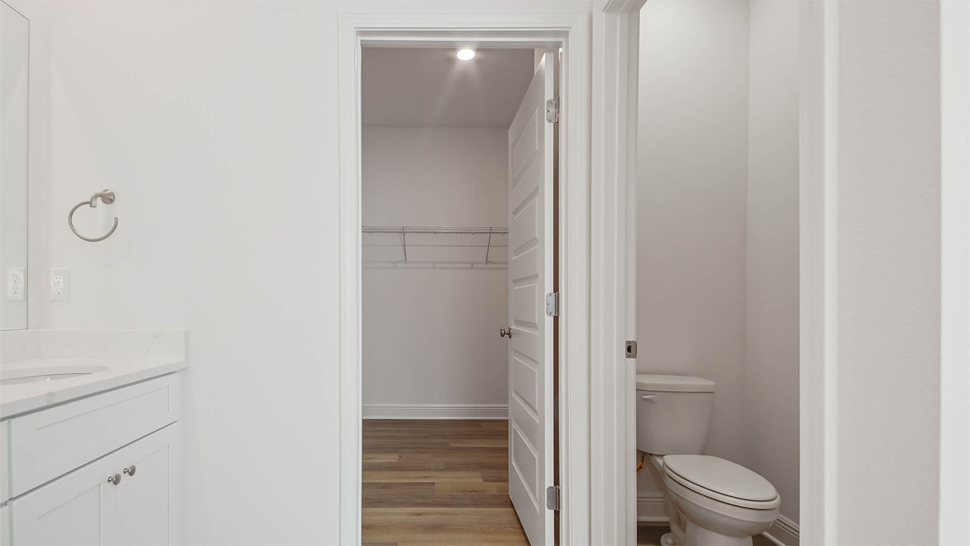 Primary bathroom with walk in closet and EVP flooring and water closet.