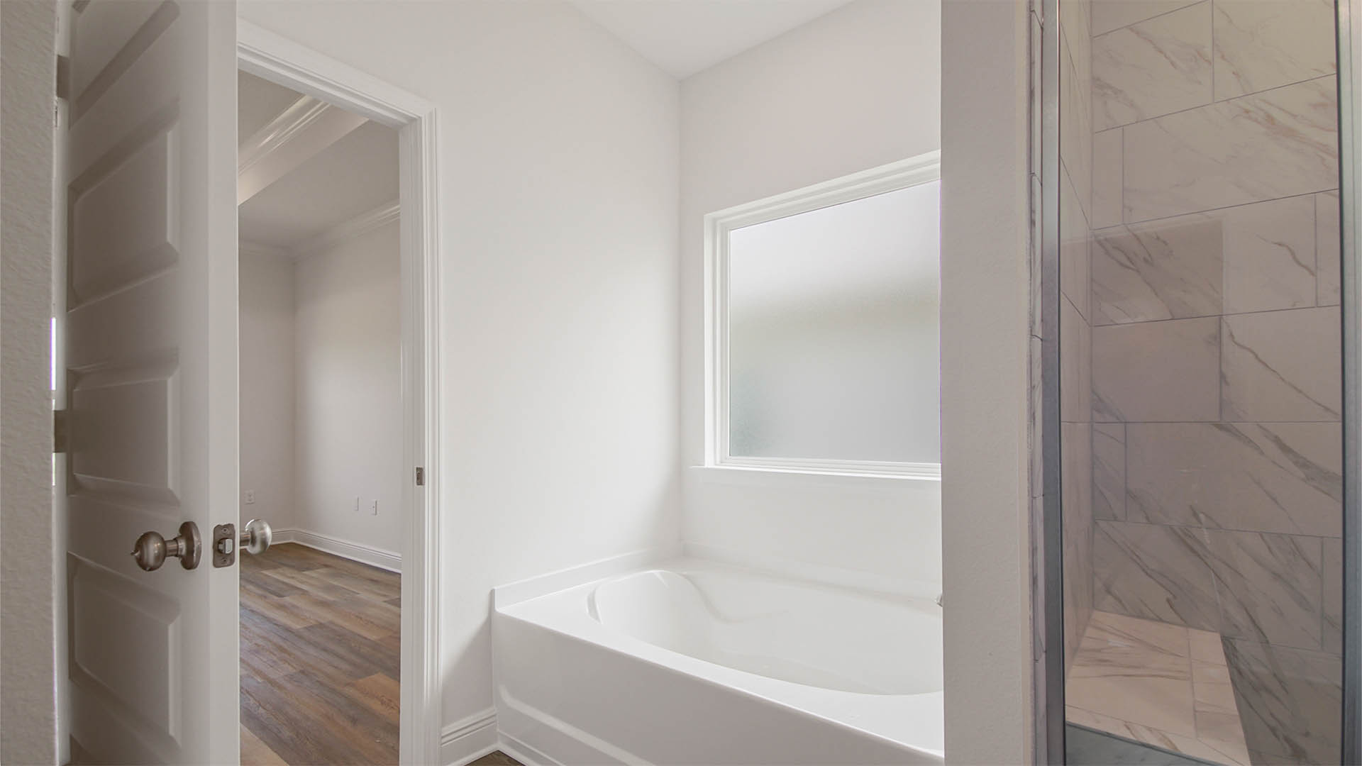 Primary bathroom with EVP flooring and large soaking tub.