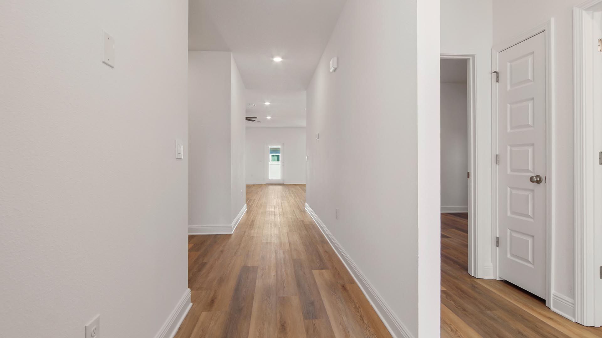 Foyer with EVP flooring and hallway to guest bedrooms and full bathroom and linen closet.