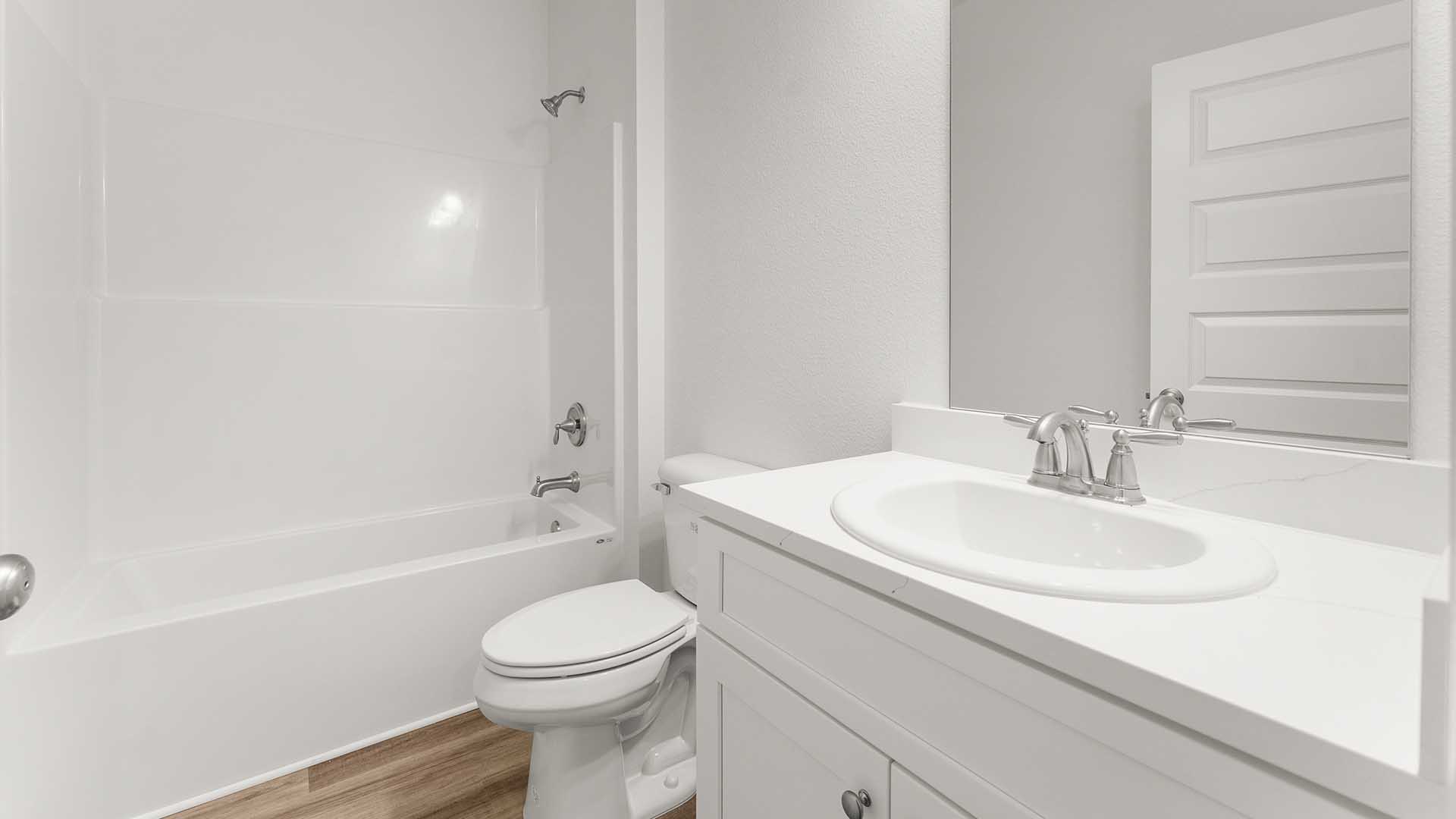 The shared bathroom has a single vanity with quartz countertops and lower cabinetry as well as a shower and tub combination