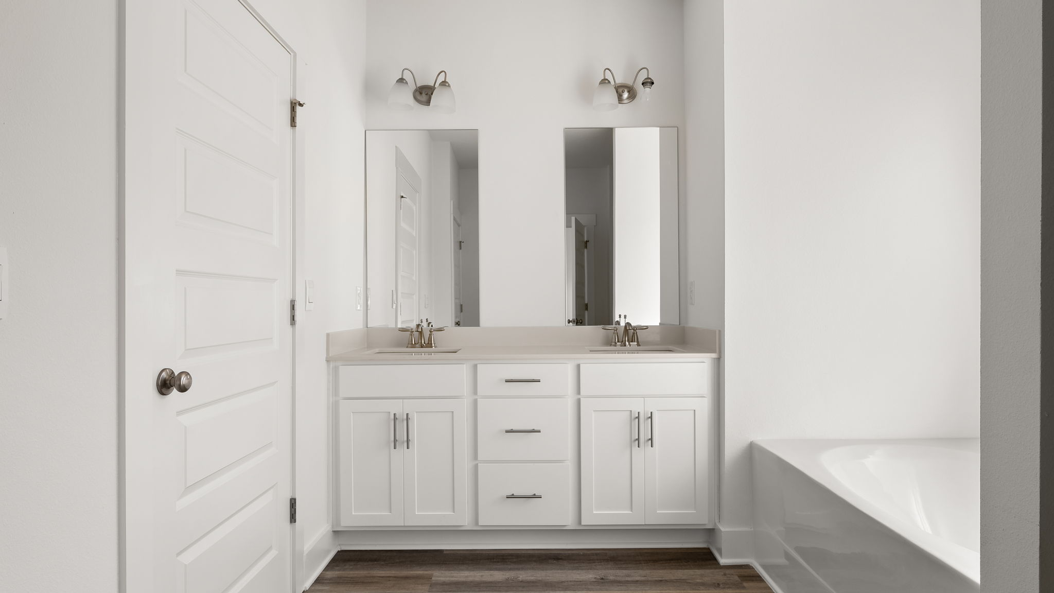 The primary bathroom features a dual sink vanity with quartz countertops and lower cabinetry for storage
