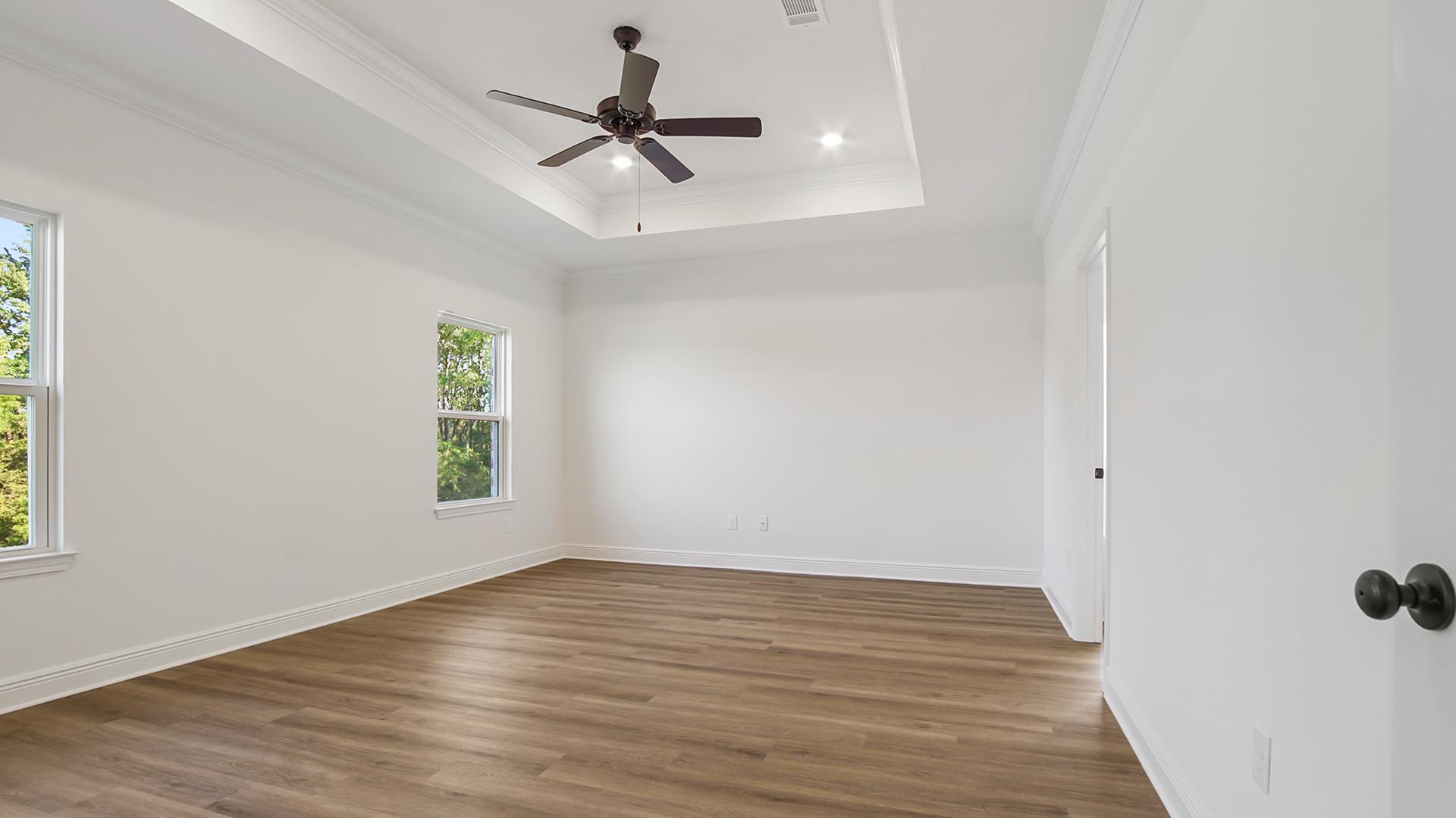 Primary bedroom of the Camden features trey ceiling and fan with EVP flooring