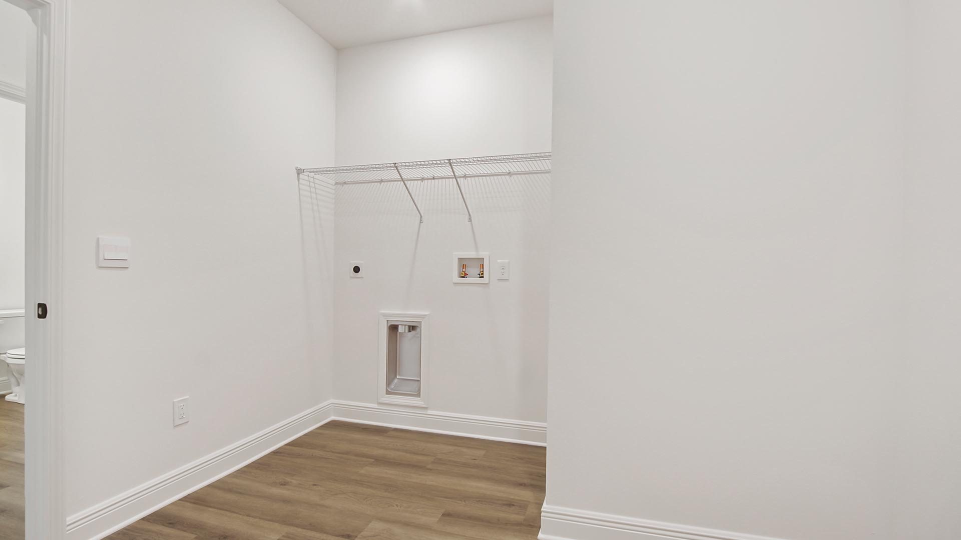 The Camden has a large laundry room with shelf and space for a full size washer and dryer