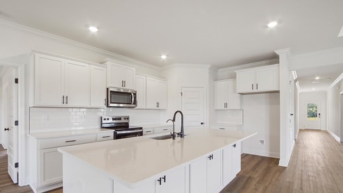 Stunning interior features in the kitchen with quartz countertops and beautiful white cabinetry