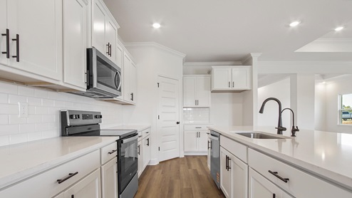The kitchen impresses with tile backsplash and stainless appliances