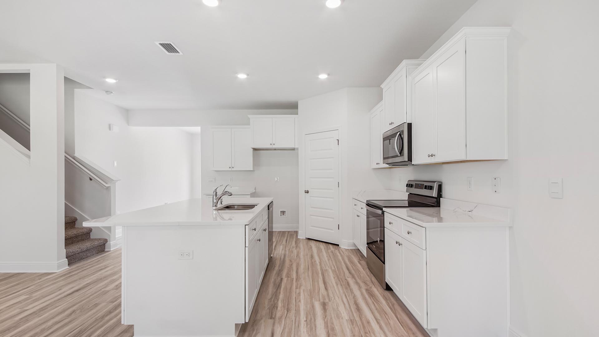 The kitchen has beautiful white cabinetry