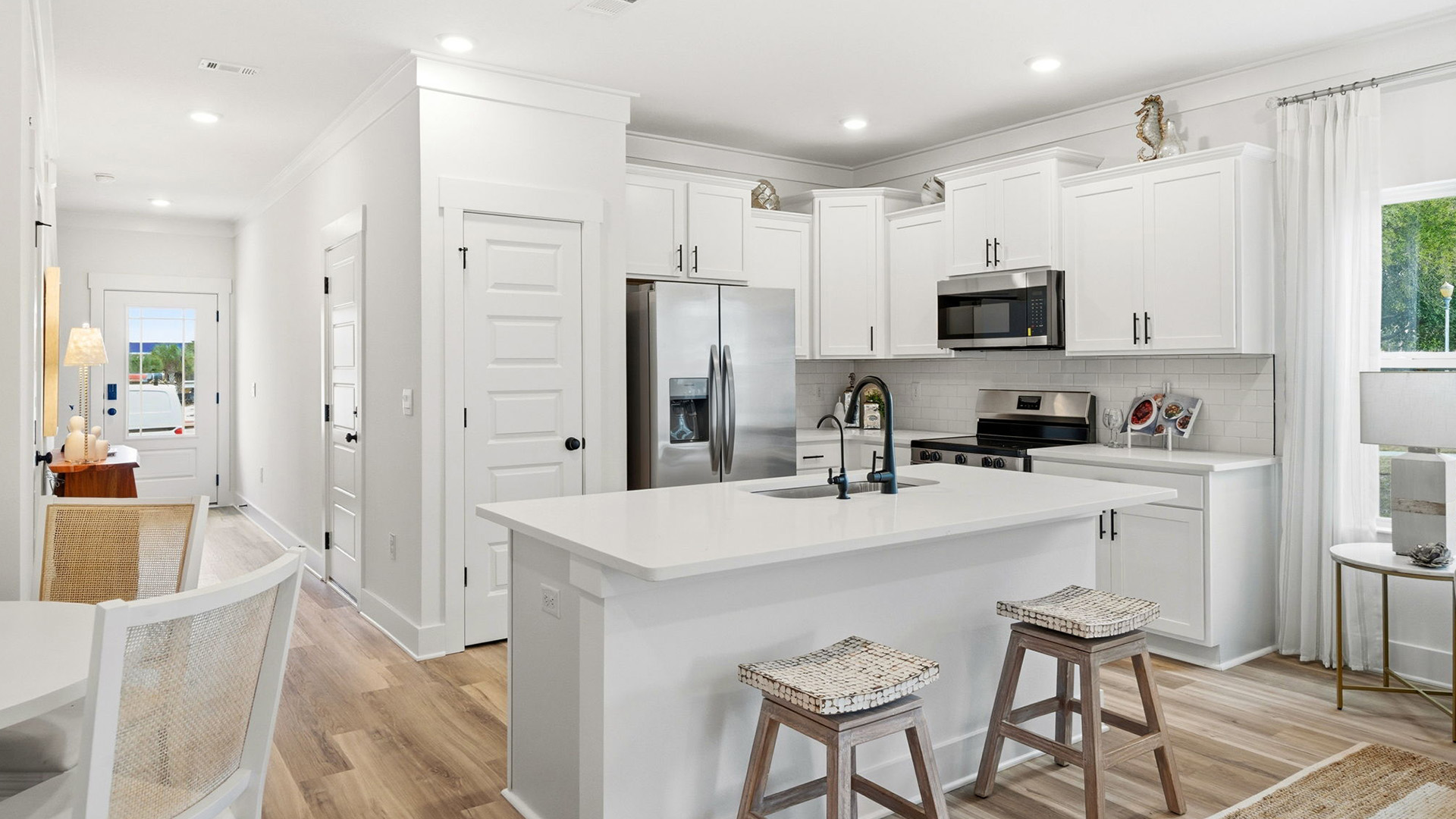 The kitchen has upper and lower cabinetry with a center island and quartz countertops
