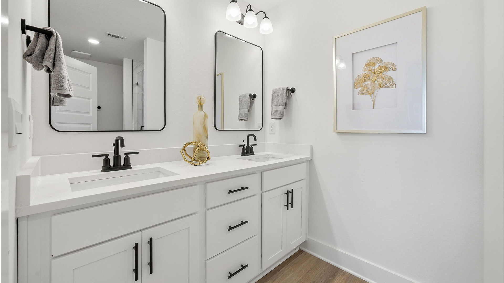 The primary bathroom has a dual sink vanity with lower cabinetry for storage
