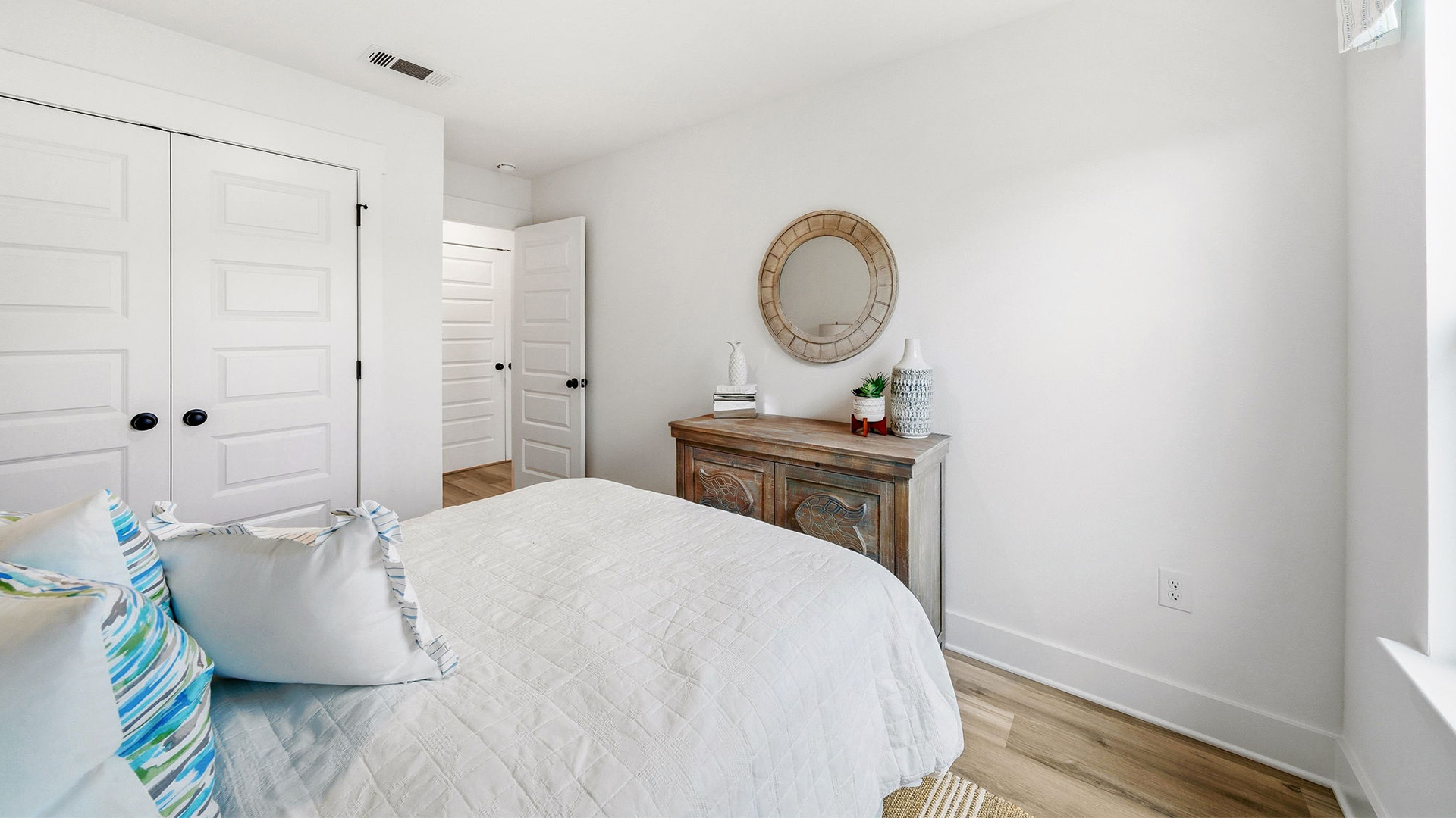 This image shows the first of two guest rooms with a queen bed