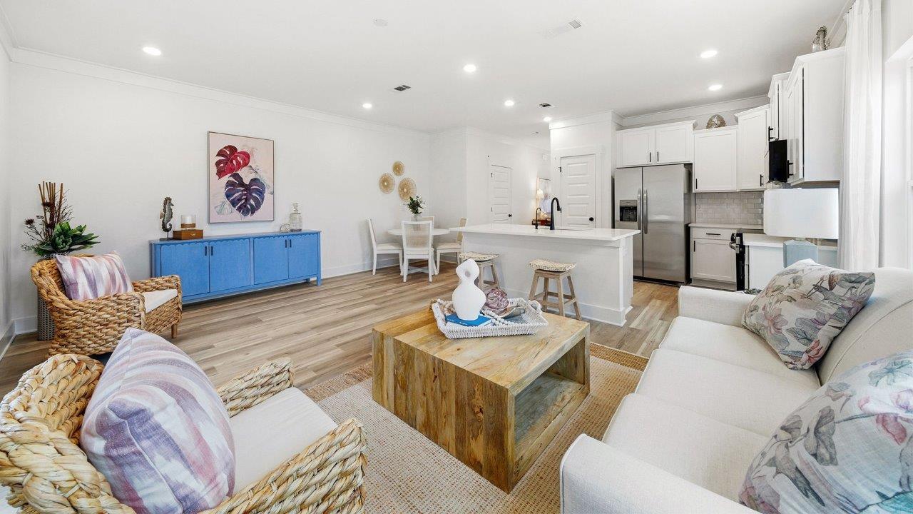 The furnished model has a full living room set and dining table