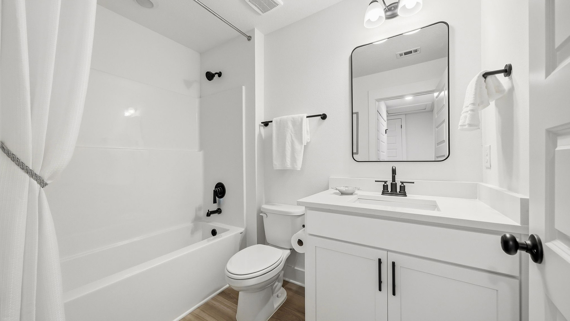 The shared bathroom has a shower tub combination