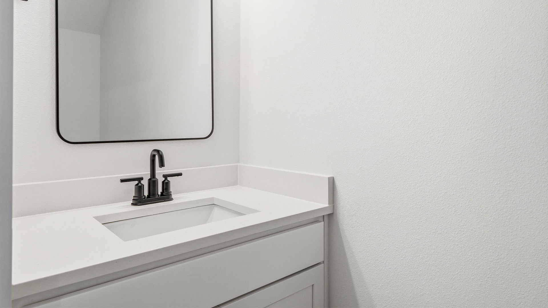 The shared bathroom has single vanity with lower cabinetry for storage
